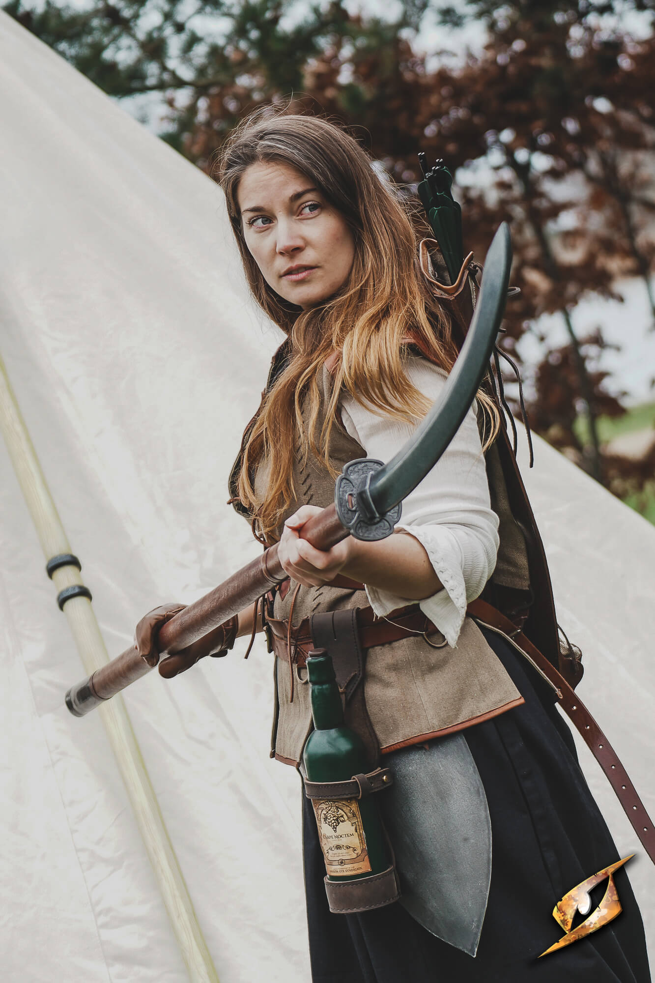 A woman holding a Naginata compact, showcasing its curved blade while dressed in period attire.