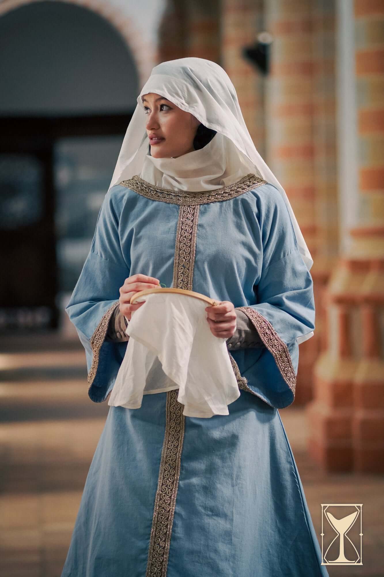 Overtunic Matilde worn by a woman, featuring wide sleeves and a woven patterned trim, showcasing historical style.