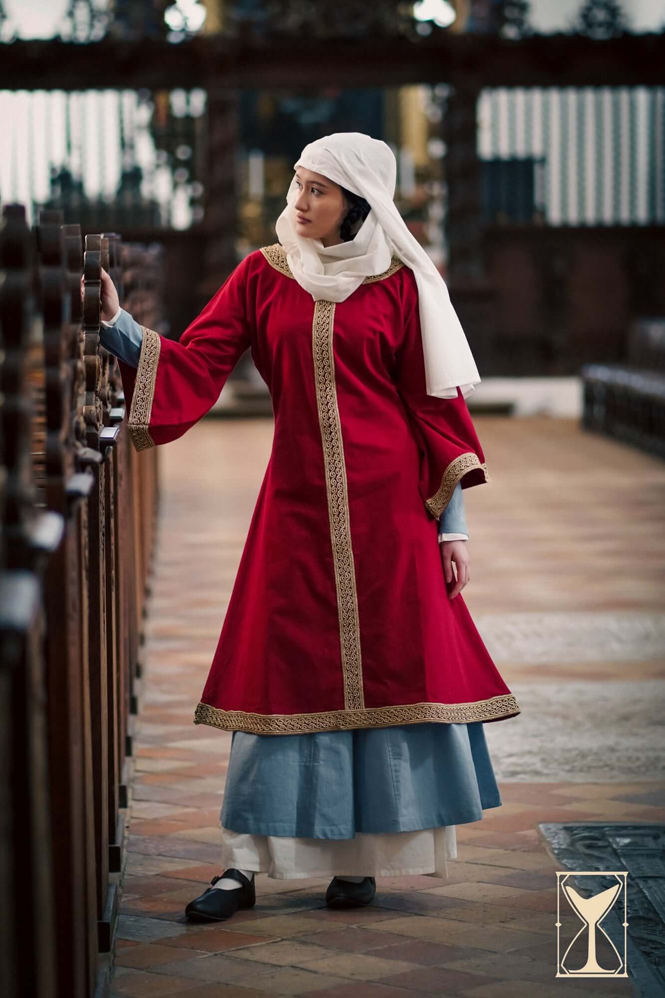 Overtunic Matilde worn by a woman, featuring wide sleeves and woven patterned trim in a historical setting.