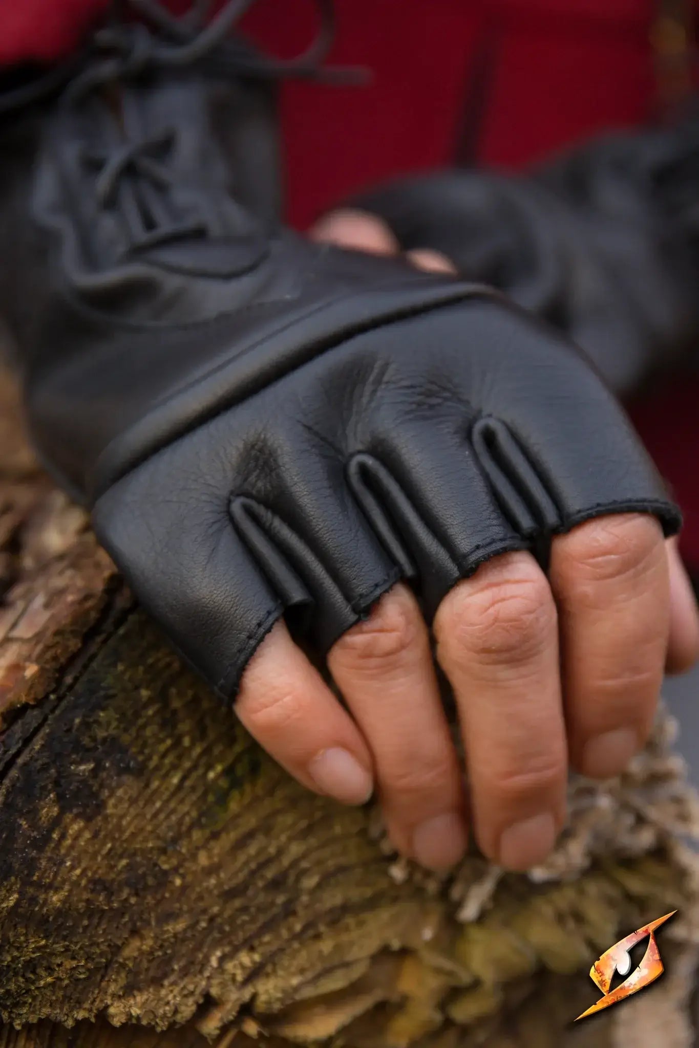 Black Thief Gloves on a hand resting on a wooden surface, showcasing their detailed design and craftsmanship.