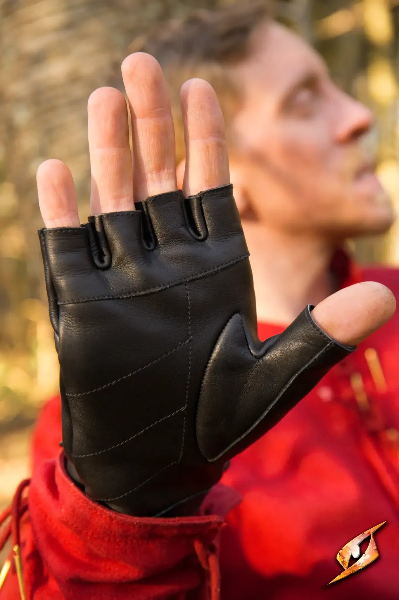 Close-up of Thief Gloves worn by a person in a red outfit, showcasing their sleek design and flexibility.