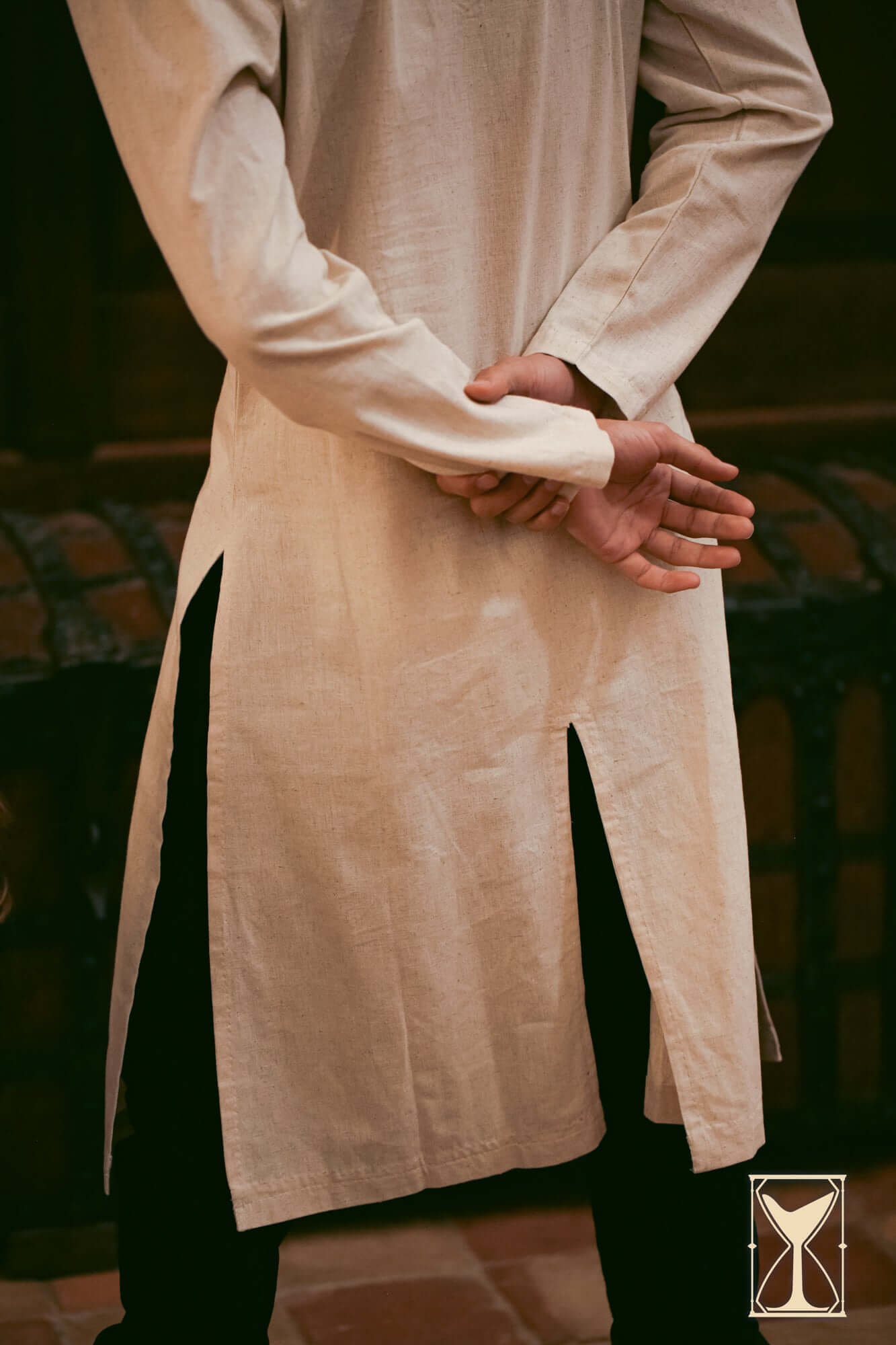 Model showcasing the back view of the Medieval Riding Tunic, highlighting deep splits for movement.