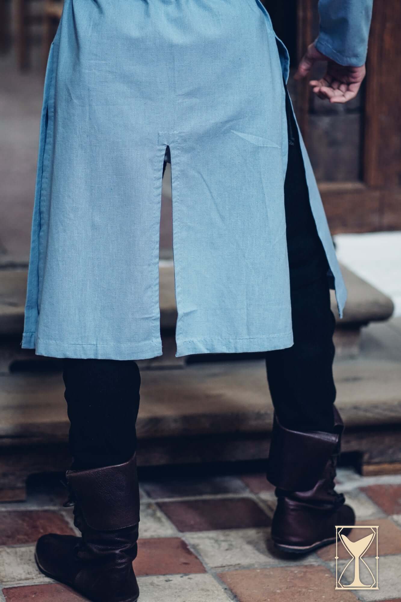 Back view of a person wearing a Medieval Riding Tunic with deep splits for enhanced movement.