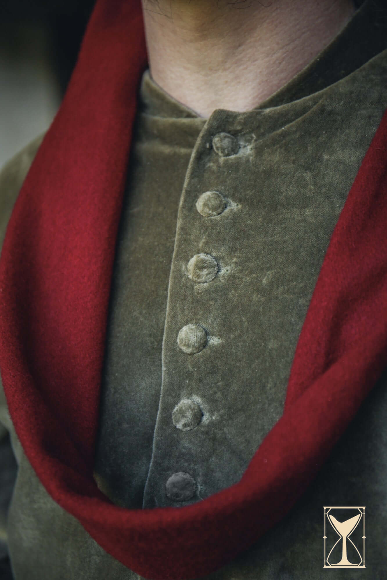 Cotehardie Bonifacio featuring a sharp fit with a distinctive red scarf and buttoned detail.
