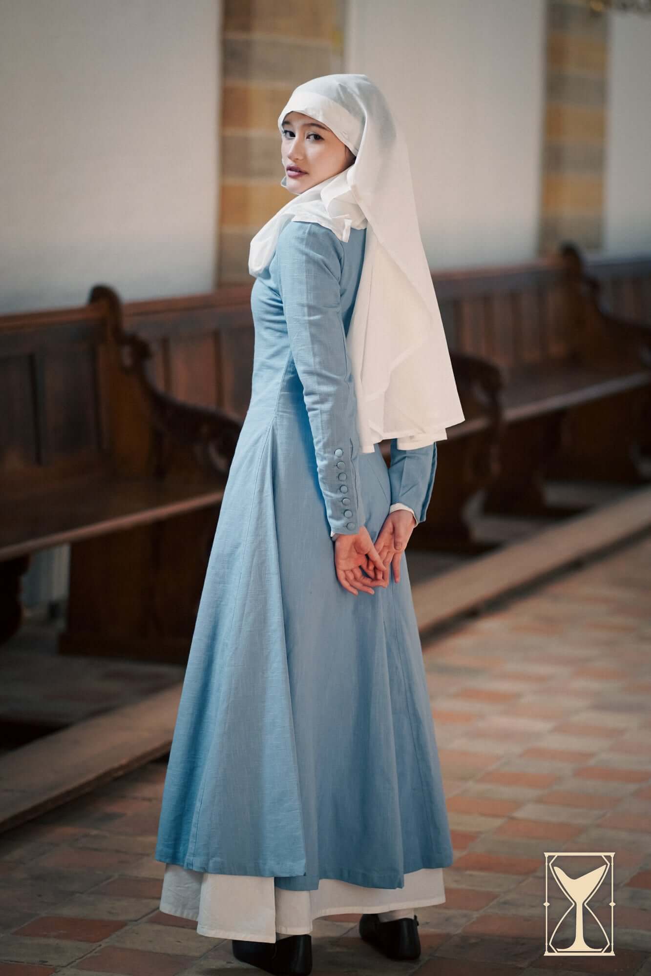 Cotehardie Marian dress showcased on model in a historical setting, featuring a tailored silhouette and central lacing.