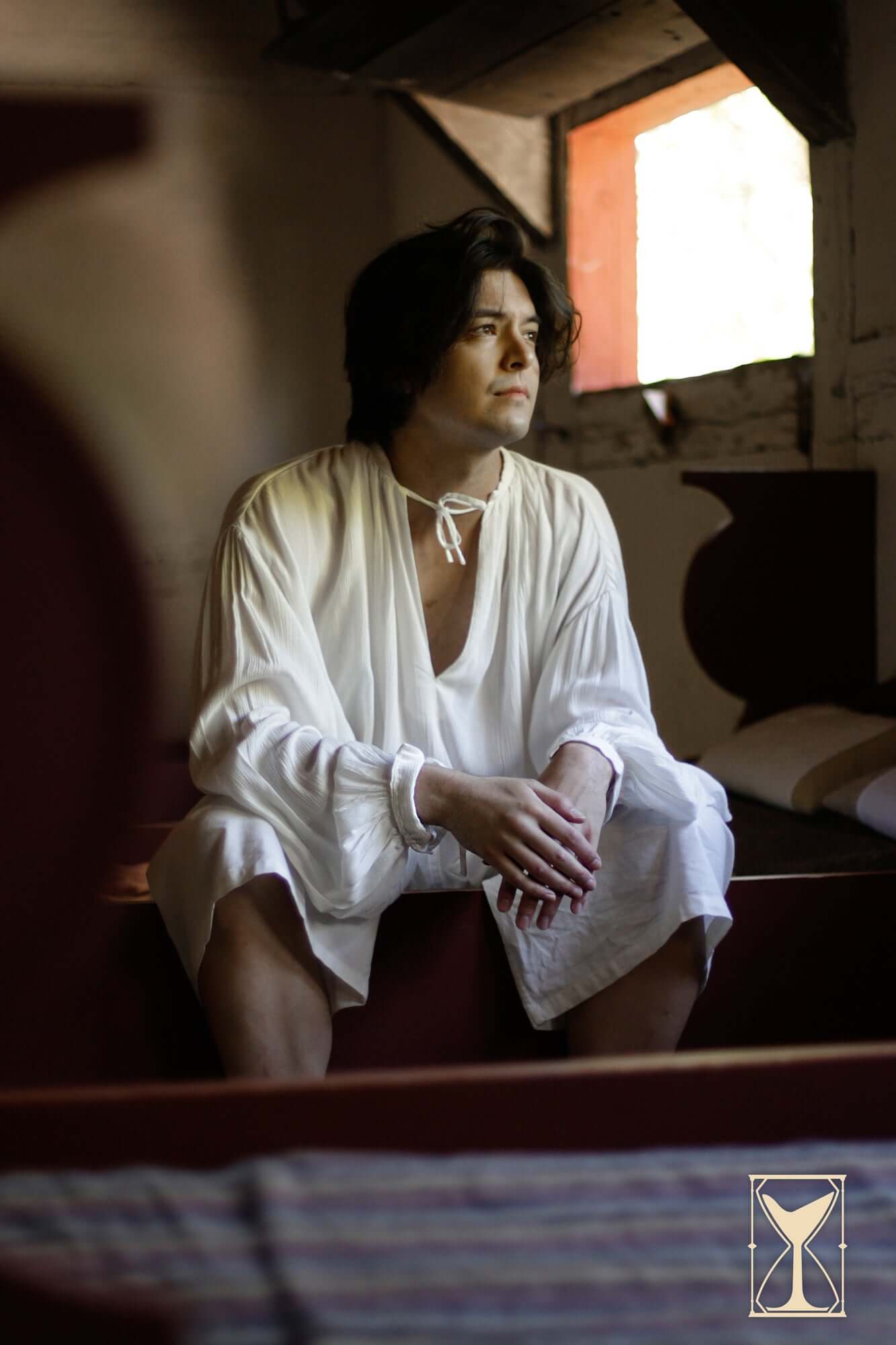 Shirt Bartholomew worn by a model sitting in a historical setting, showcasing relaxed-fit Medieval apparel.