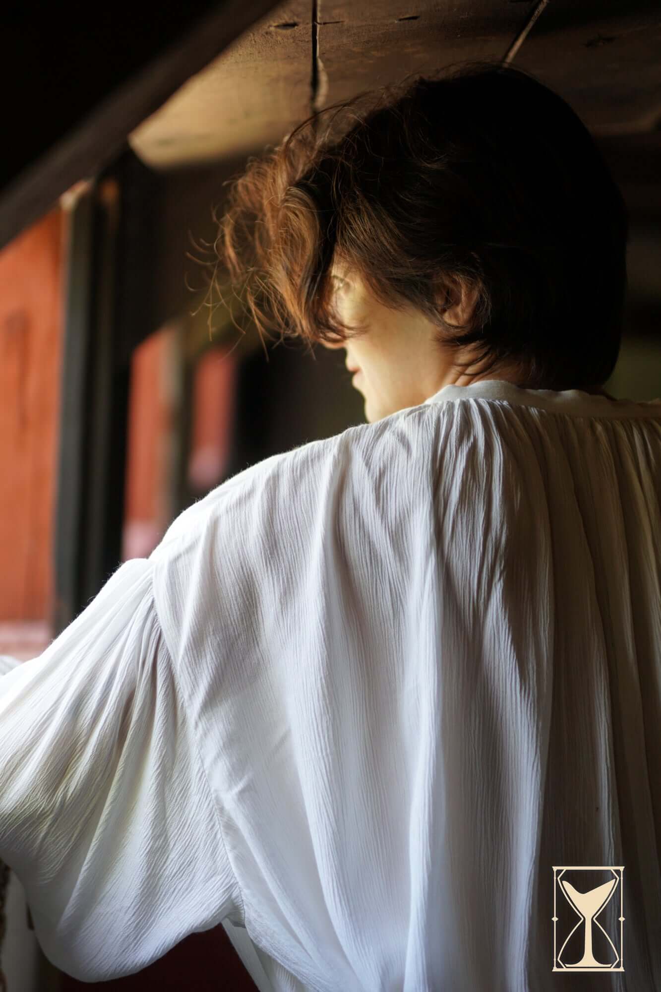 A person wearing the Shirt Bartholomew gazing out a window, showcasing its relaxed-fit design.