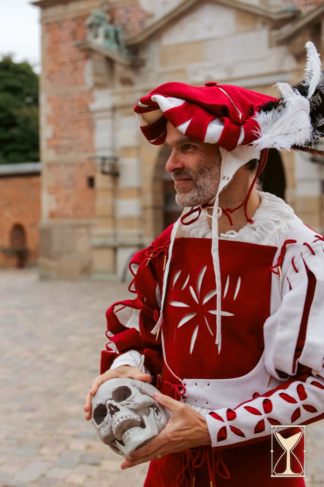 Landsknecht Hat worn by a man in traditional attire, holding a skull in a historic setting.