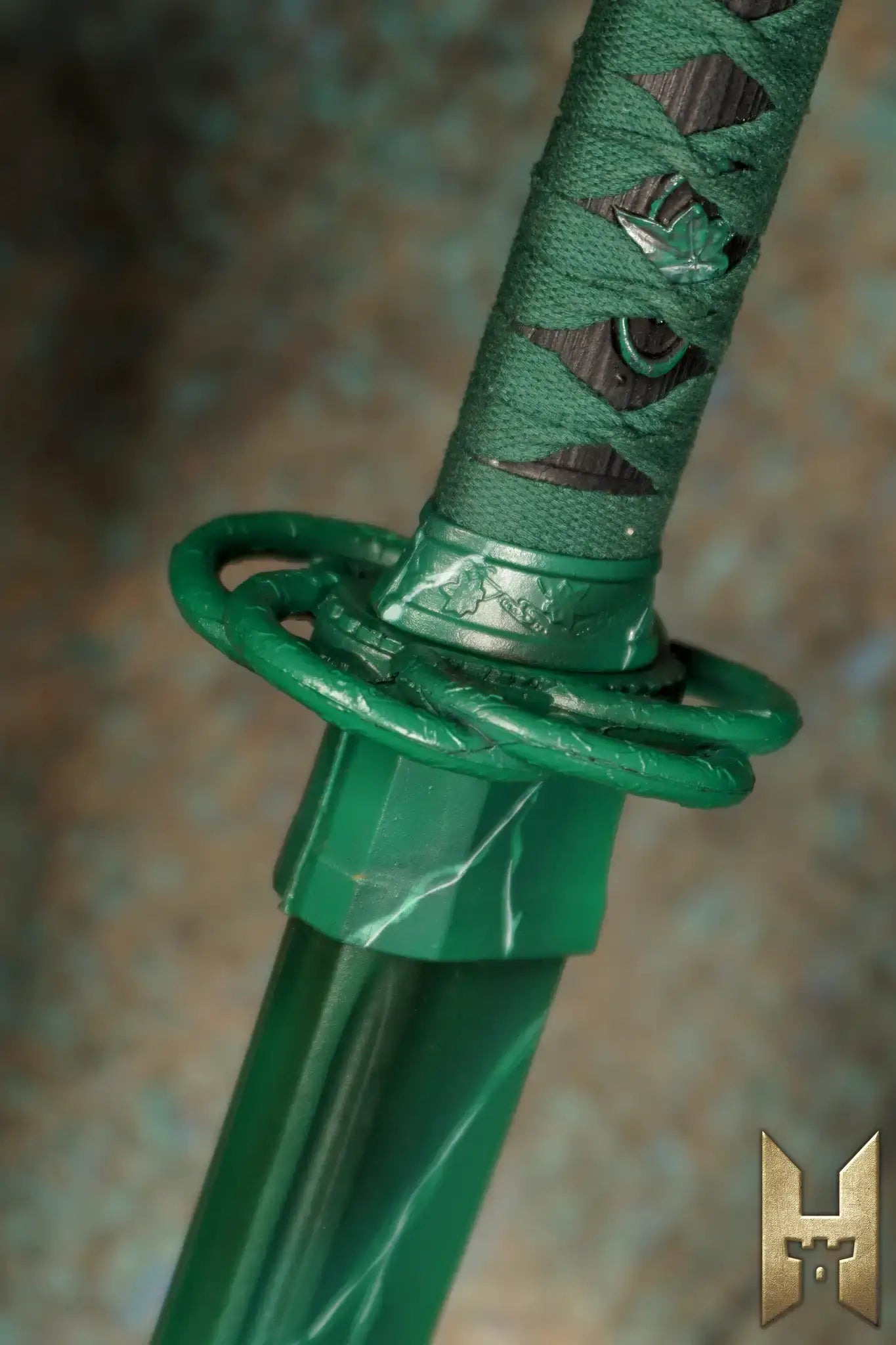 Close-up of Ryūgan the Katana handle featuring intricate green detailing and traditional design elements.