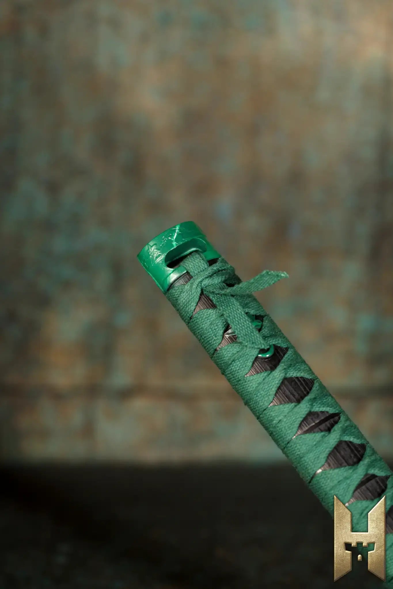 Close-up of the handle of Ryūgan the Katana, showcasing its intricate green wrapping and elegant design.