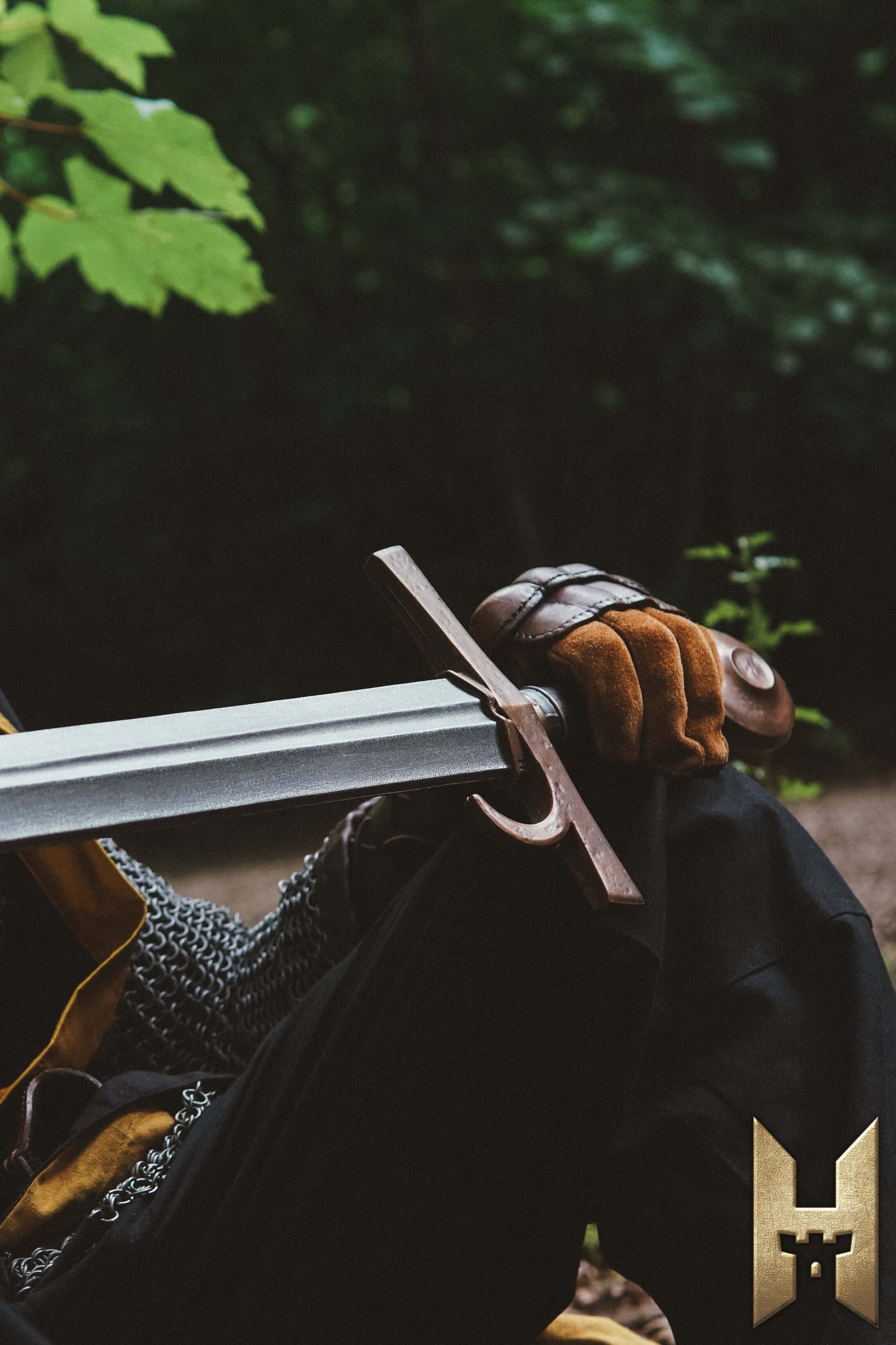 Milanese Sword resting on a warrior's knee in a forest setting, showcasing its elegant design and durable construction.