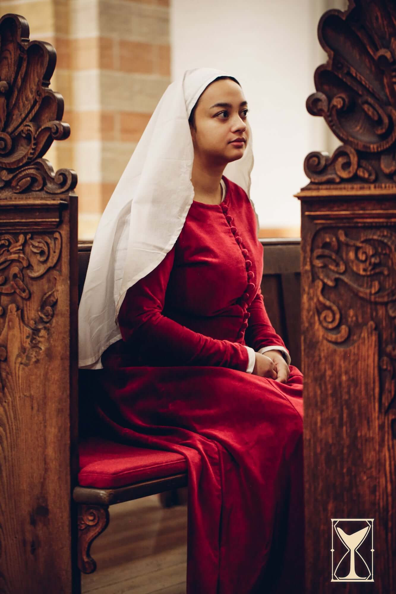 Cotehardie Colette worn by a woman seated, showcasing velvet fabric and historical late middle ages style.