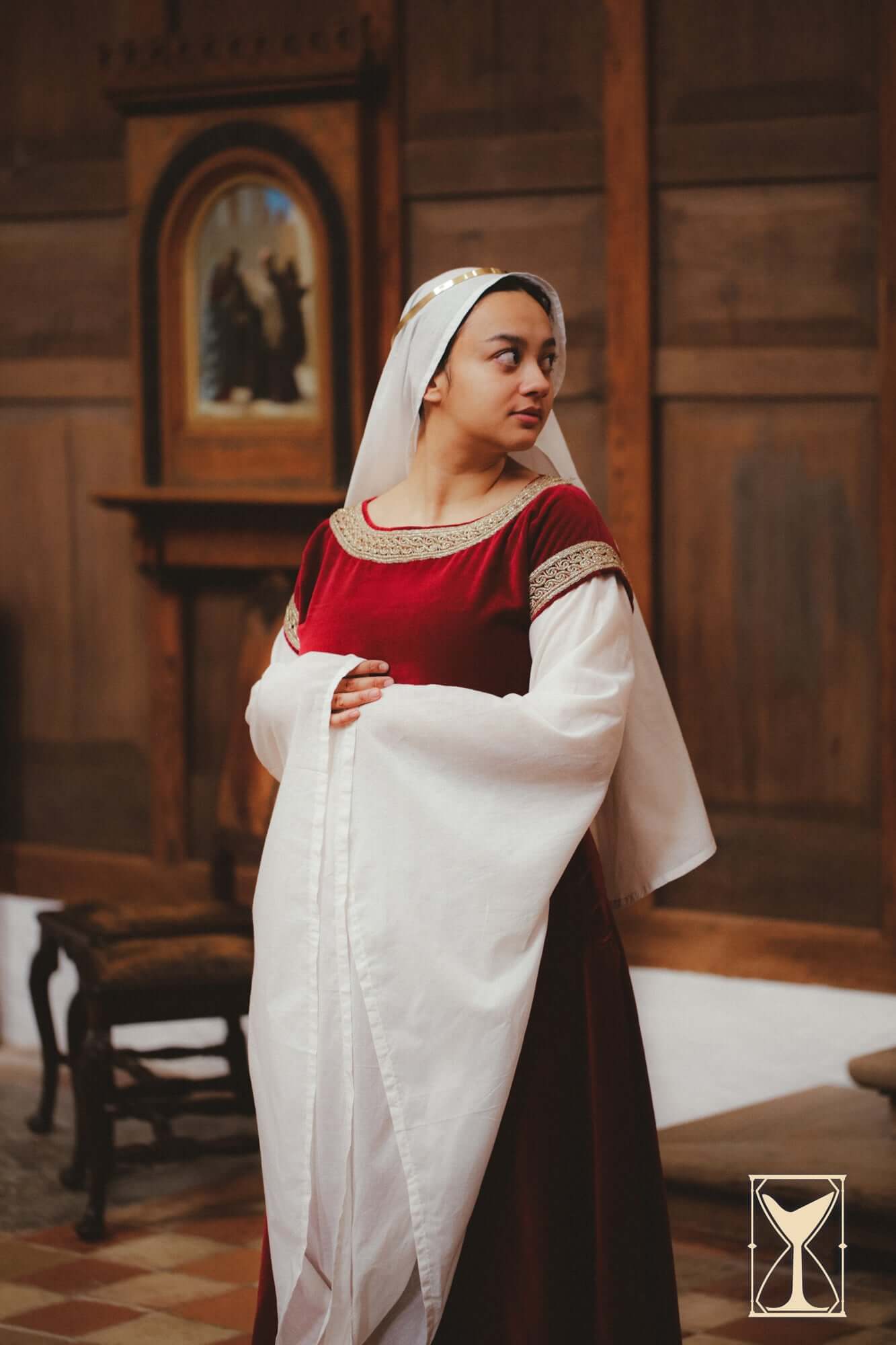 A model wearing a Bliaut Noble dress made of velvet and muslin, showcasing the elegance of 12th-century fashion.