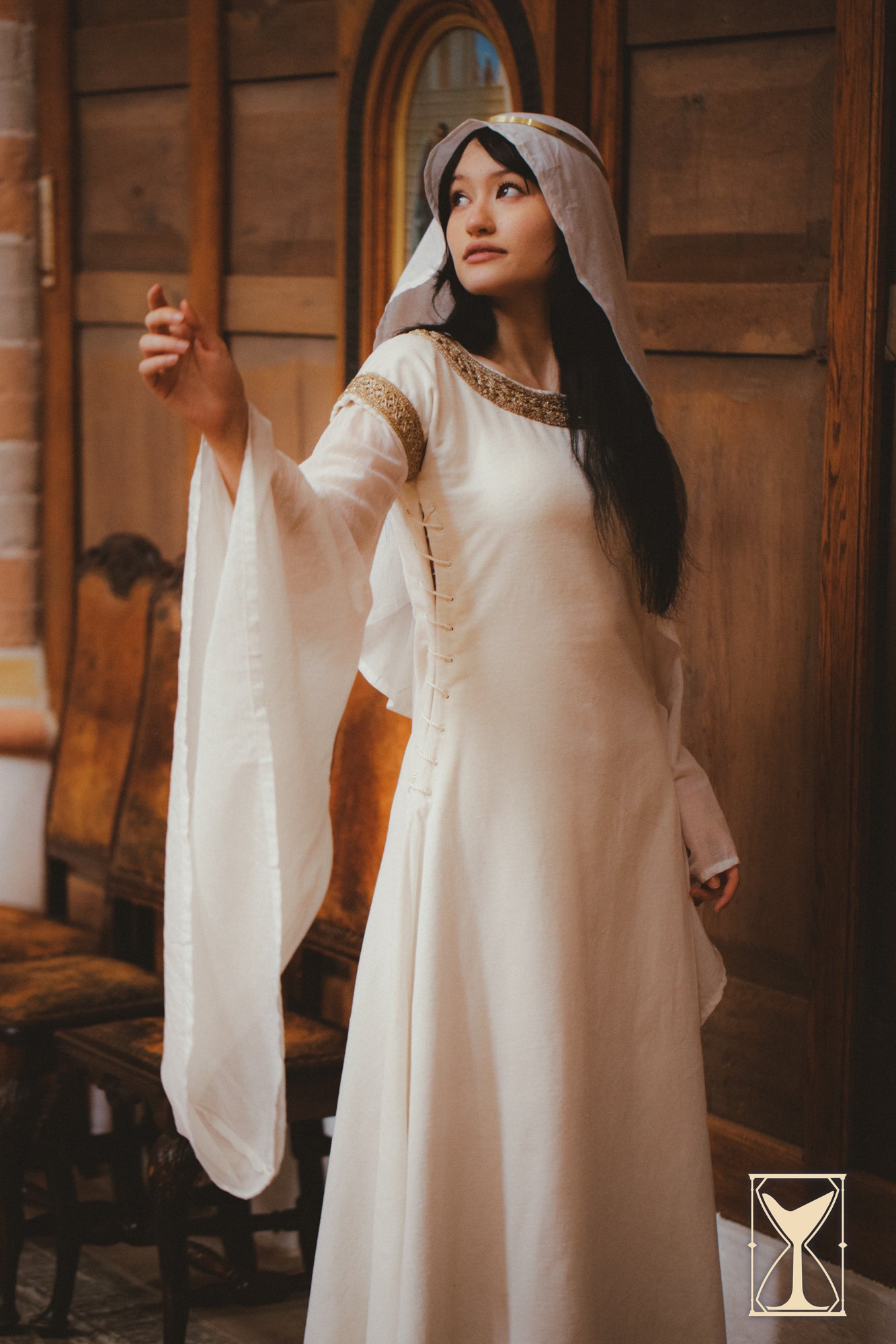Model wearing the Bliaut Noble dress, showcasing long sleeves and elegant lacing detail, inspired by 12th-century fashion.