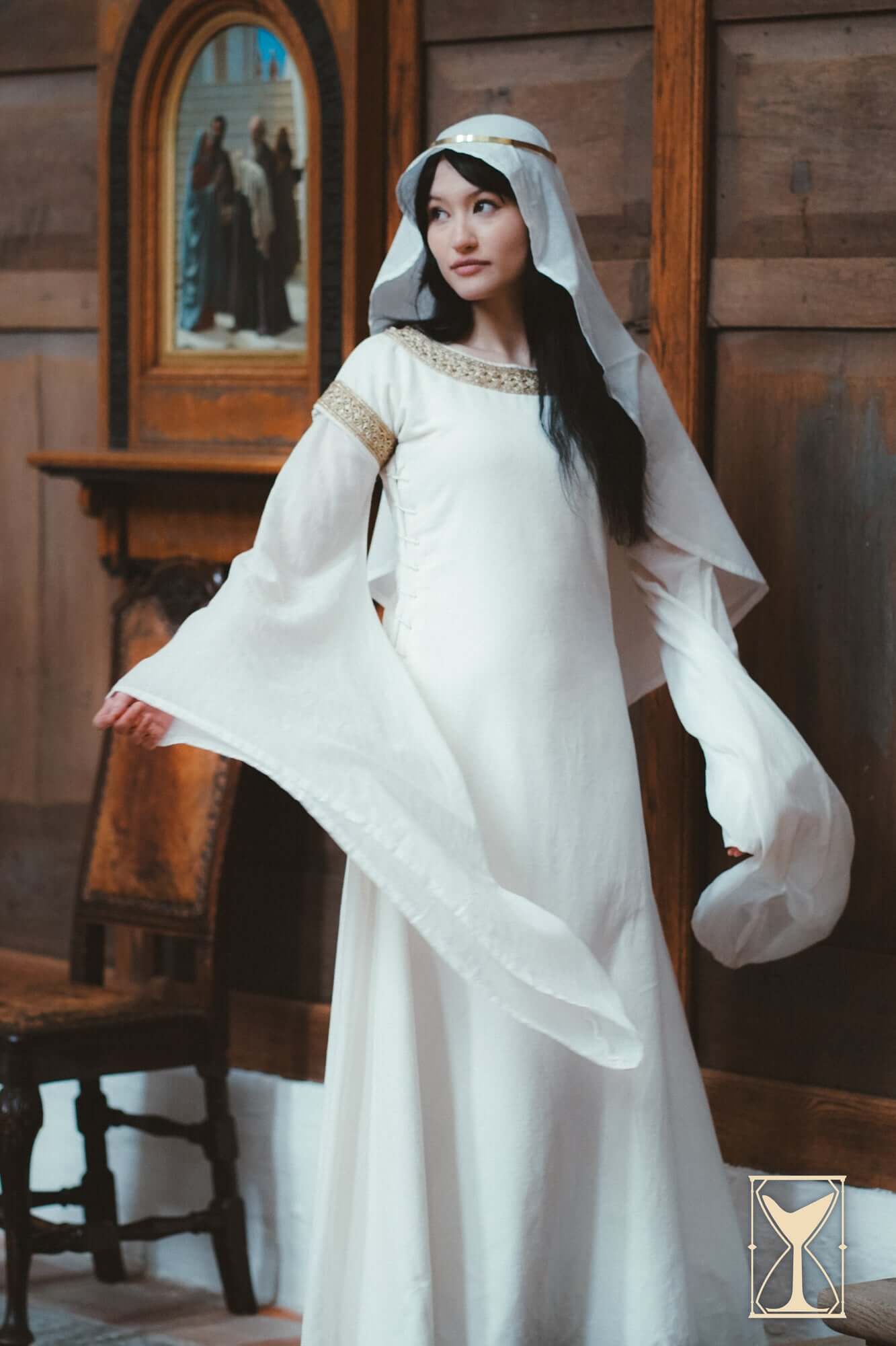 Model showcasing the Bliaut Noble, a 12th-century dress with long, flowing sleeves and elegant detailing.