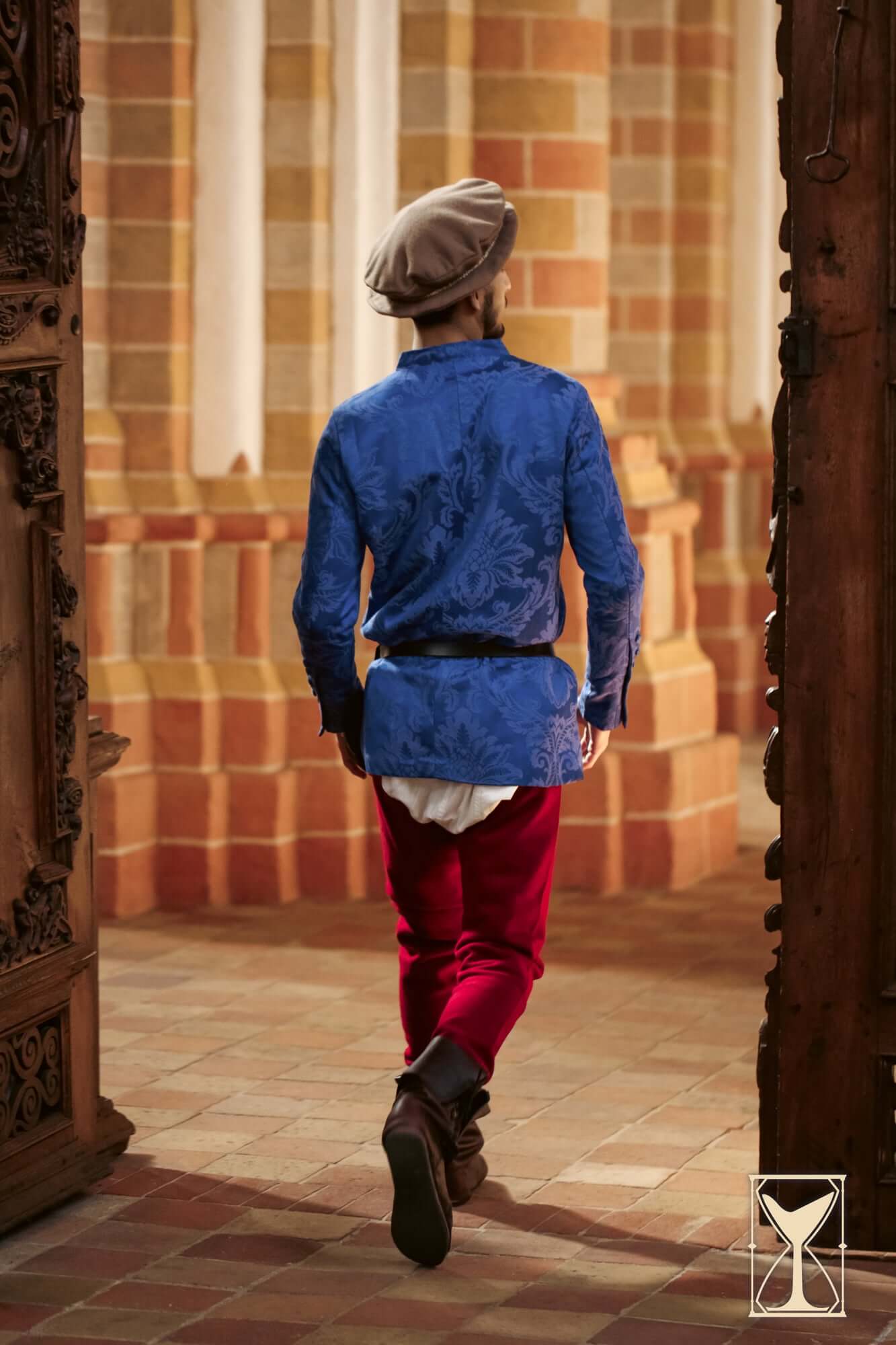 Cotehardie Rodrigo showcased in royal blue brocade, paired with red pants, representing Late Middle Ages fashion.