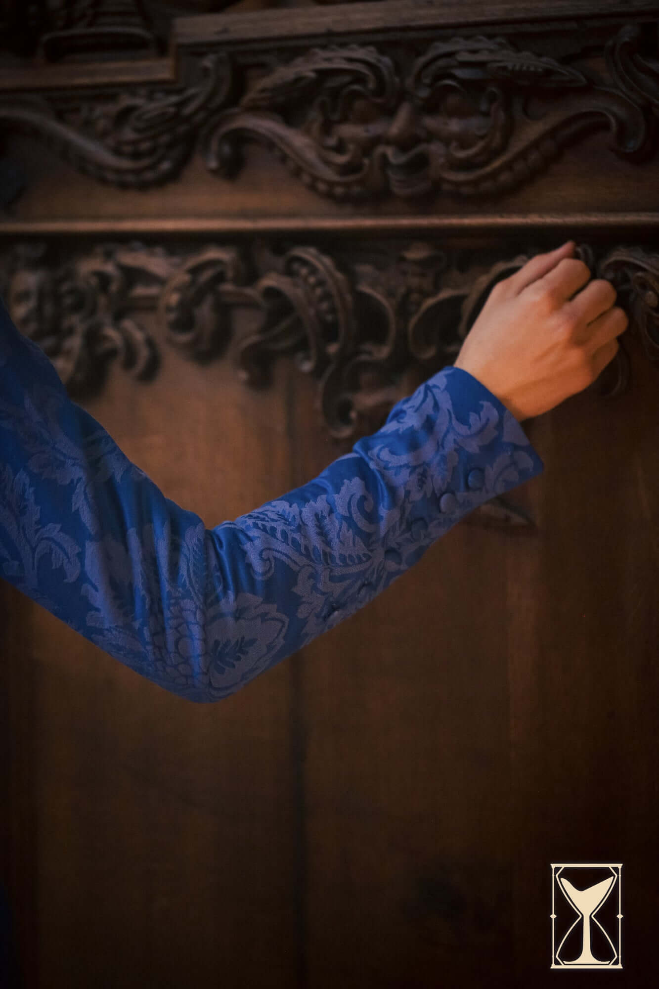 Detail of the Cotehardie Rodrigo jacket sleeve featuring rich blue brocade with jacquard pattern.