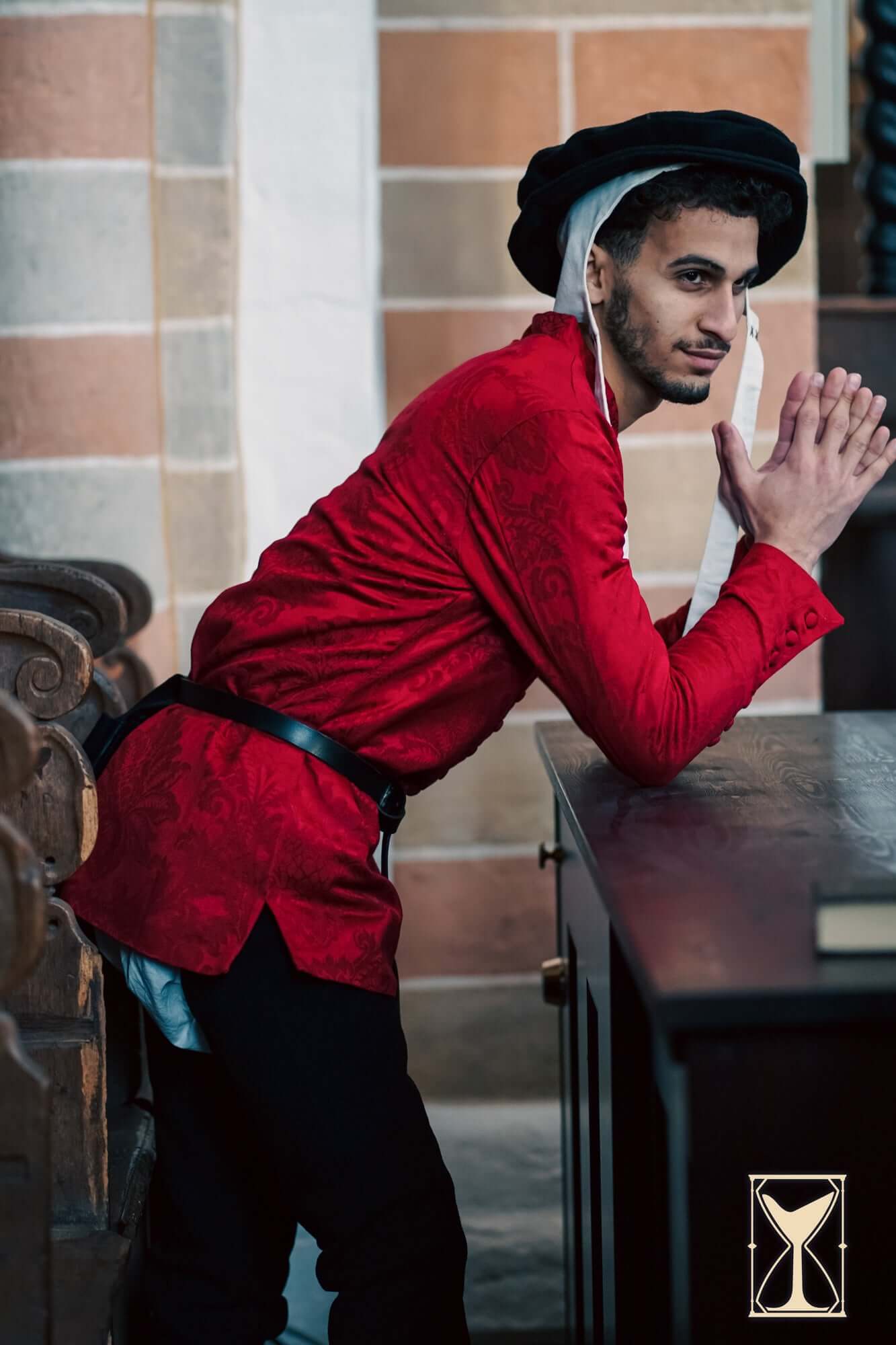 Cotehardie Rodrigo, a red brocade button-up jacket designed for the Late Middle Ages, worn by a model.