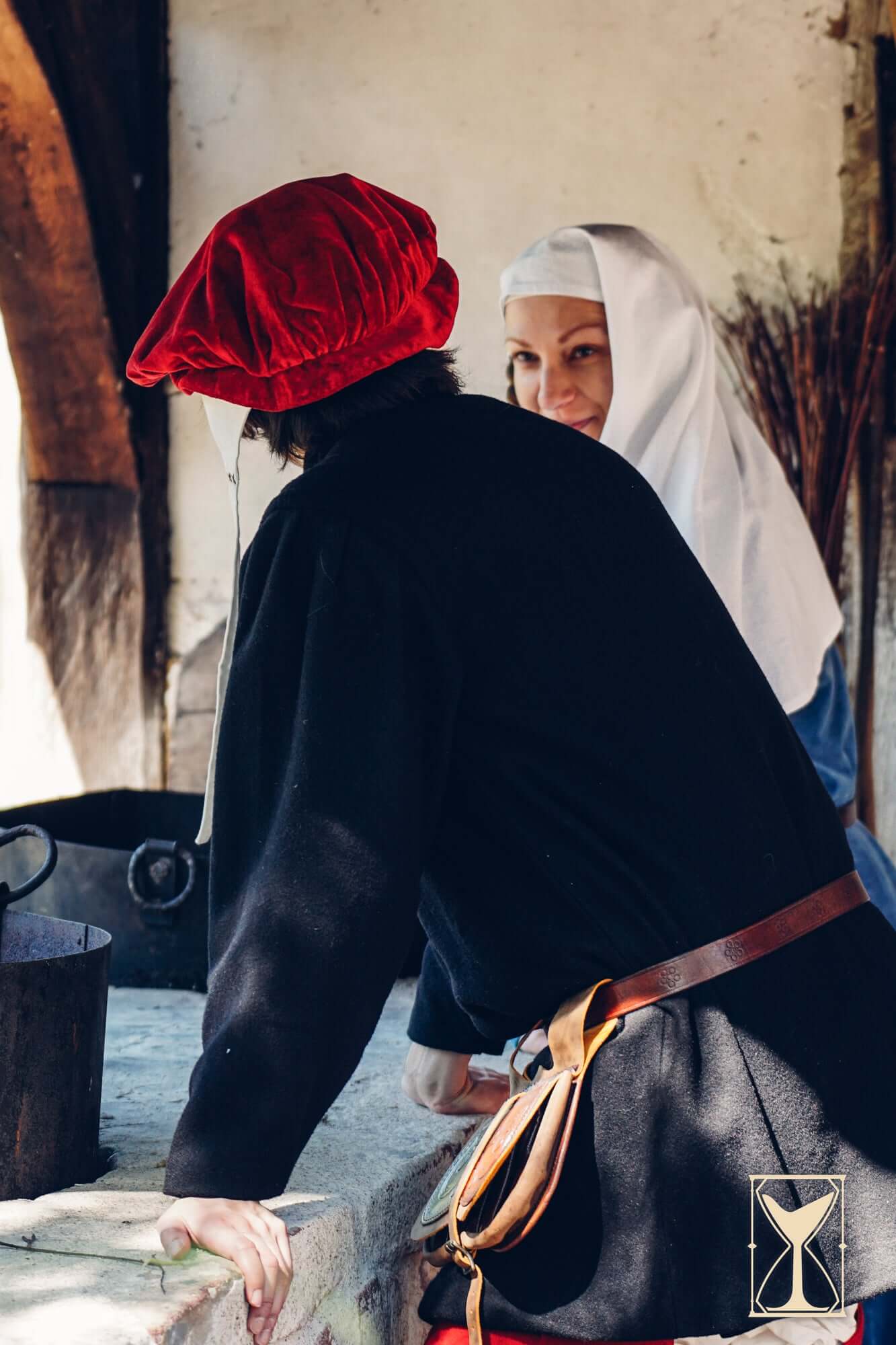 Beret Francisco worn by a man discussing with a woman in medieval attire, showcasing 15th and 16th century fashion.