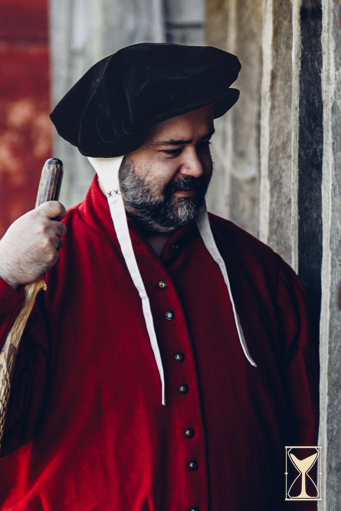 Man wearing Beret Francisco velvet hat and red attire, inspired by 15th and 16th-century fashion.