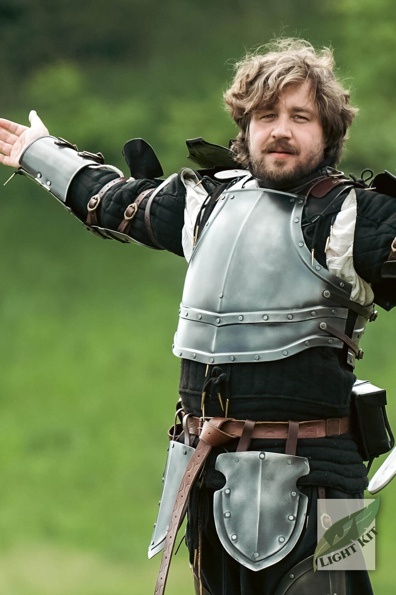 Man showcasing Captain Arm Protection - Light Kit armor outdoors in a green setting.
