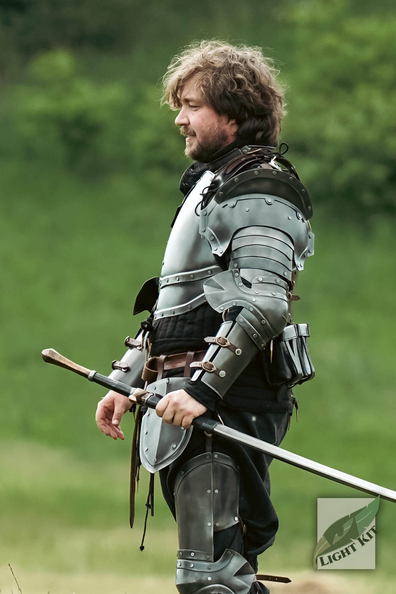 Captain Arm Protection - Light Kit displayed on a knight holding a sword in a green field.