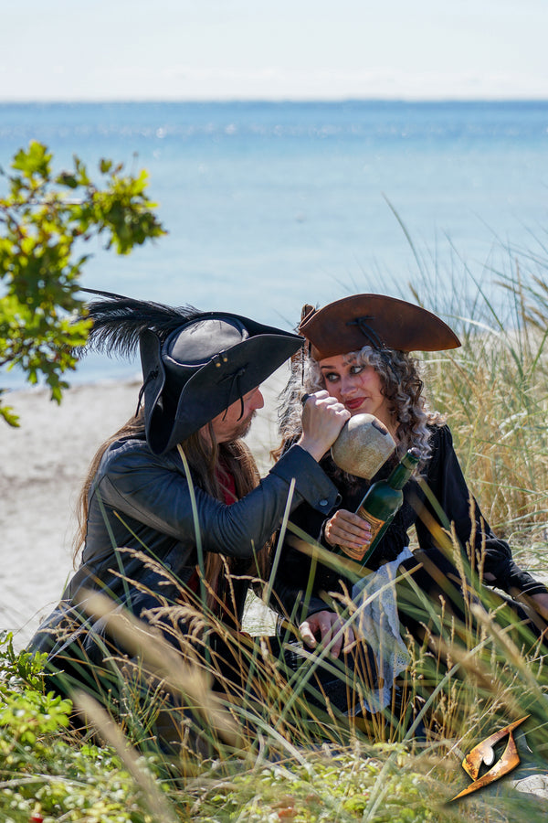 Simple Leather Pirate Tricorn Hat worn by pirates enjoying a beachside scene with drinks in hand.