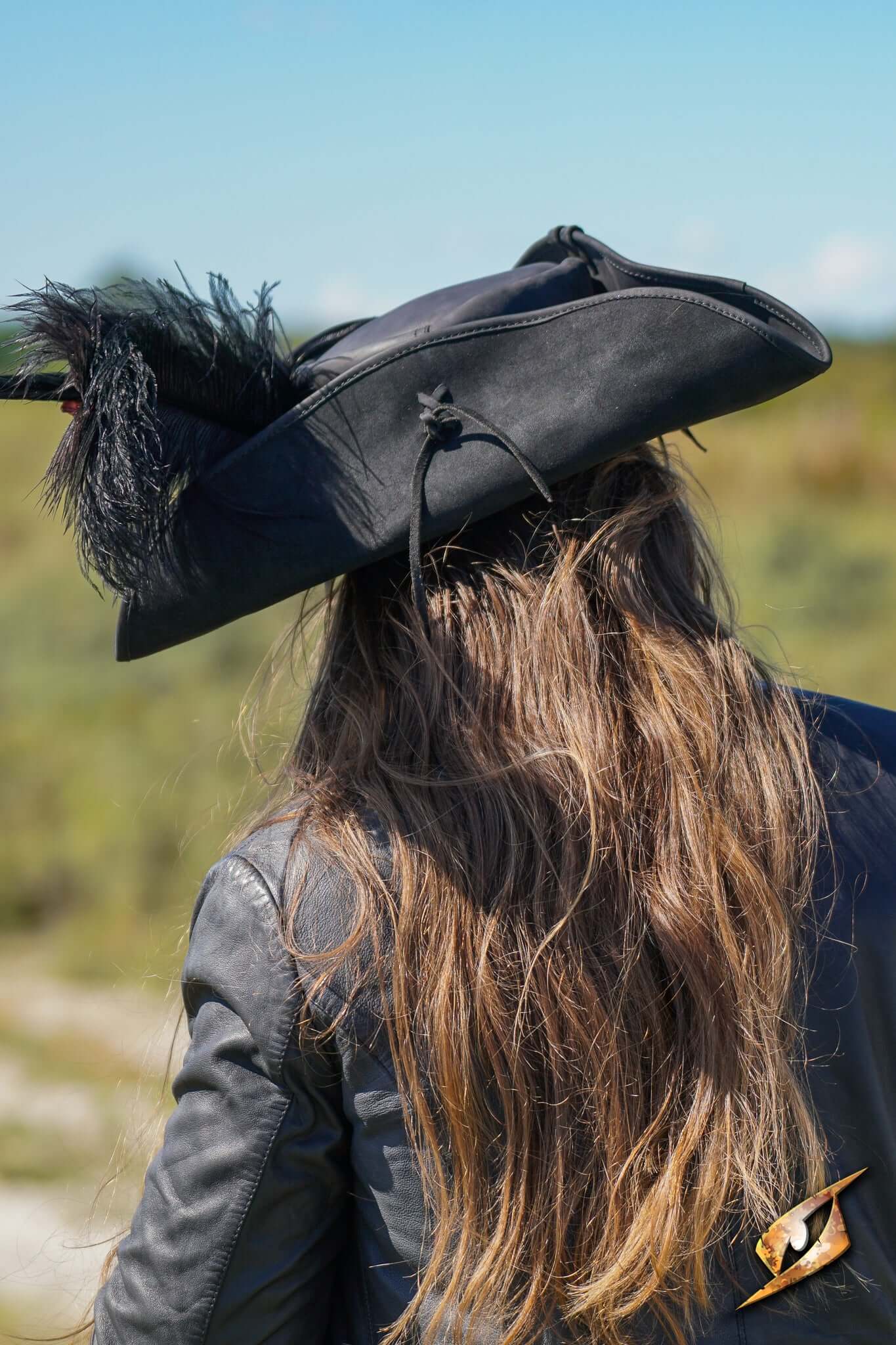 Simple Leather Pirate Tricorn Hat with feather, worn outdoors, showcasing back view and long hair.