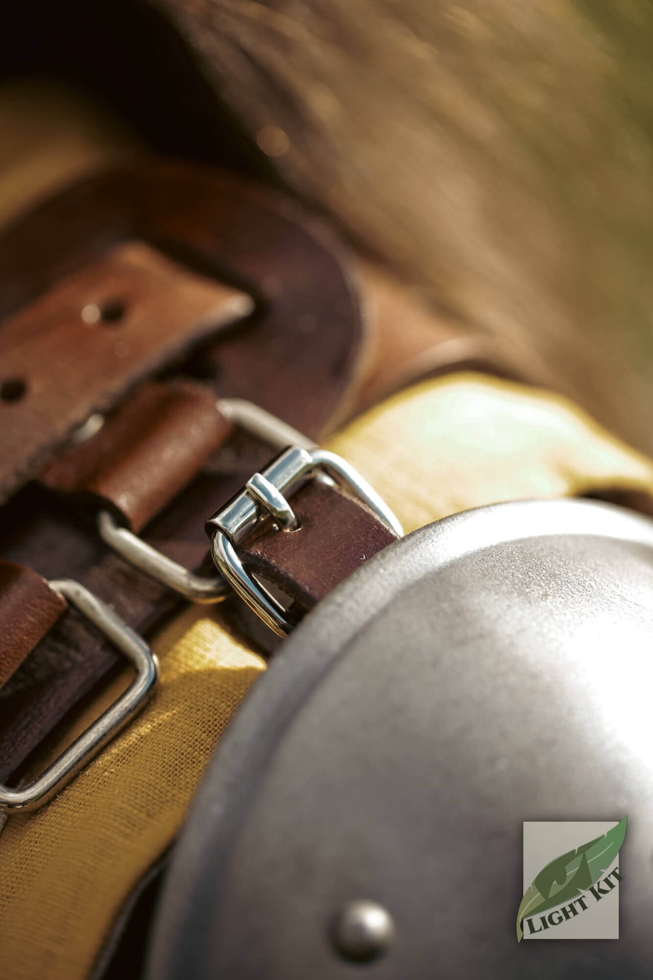 Close-up of the fastening details on the Shoulder Plate Merc - Light Kit with leather straps and metal buckles.