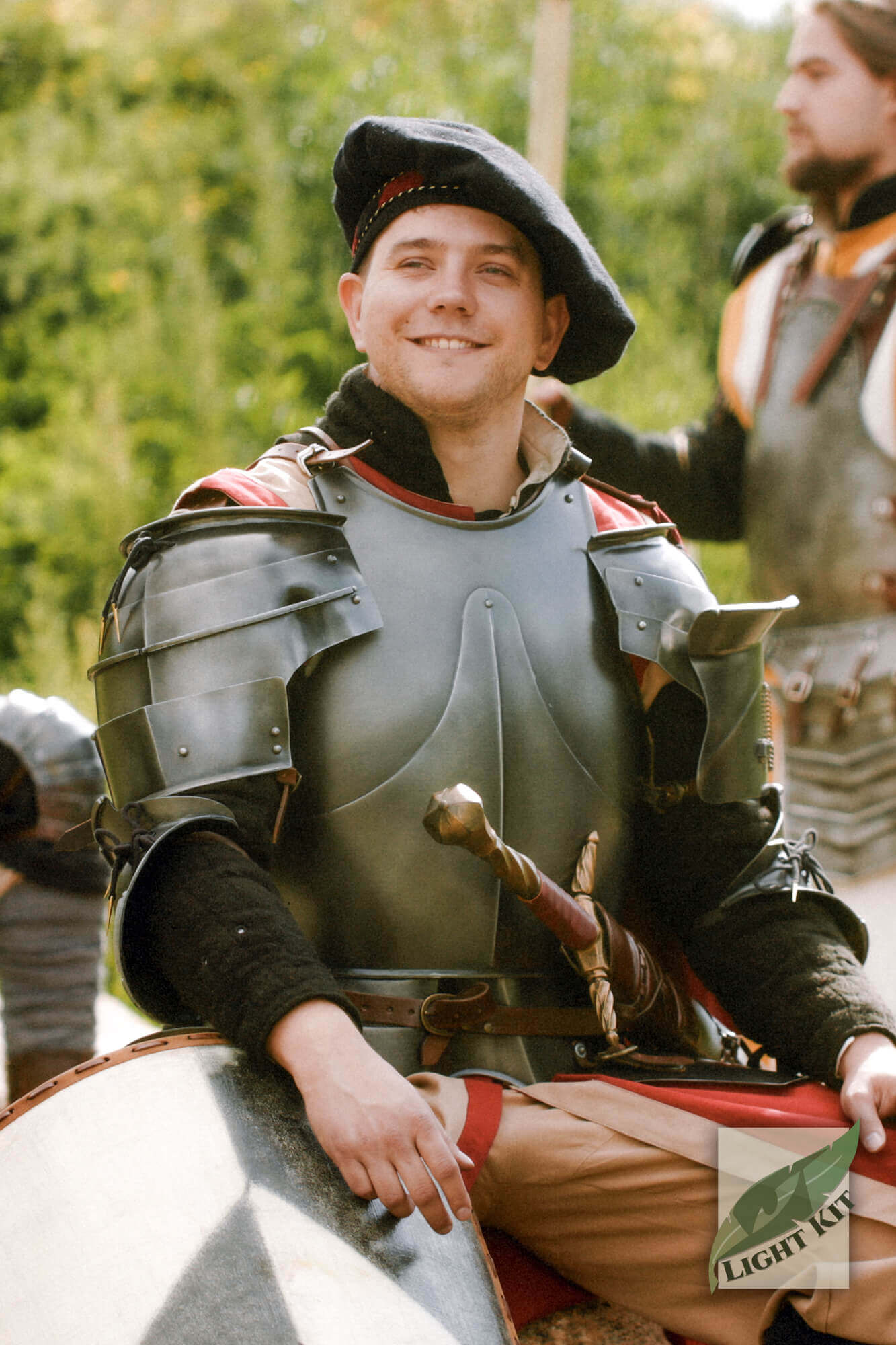 Milanese Pauldrons - Light Kit displayed by a smiling knight in armor, showcasing historical aesthetics and flexibility.