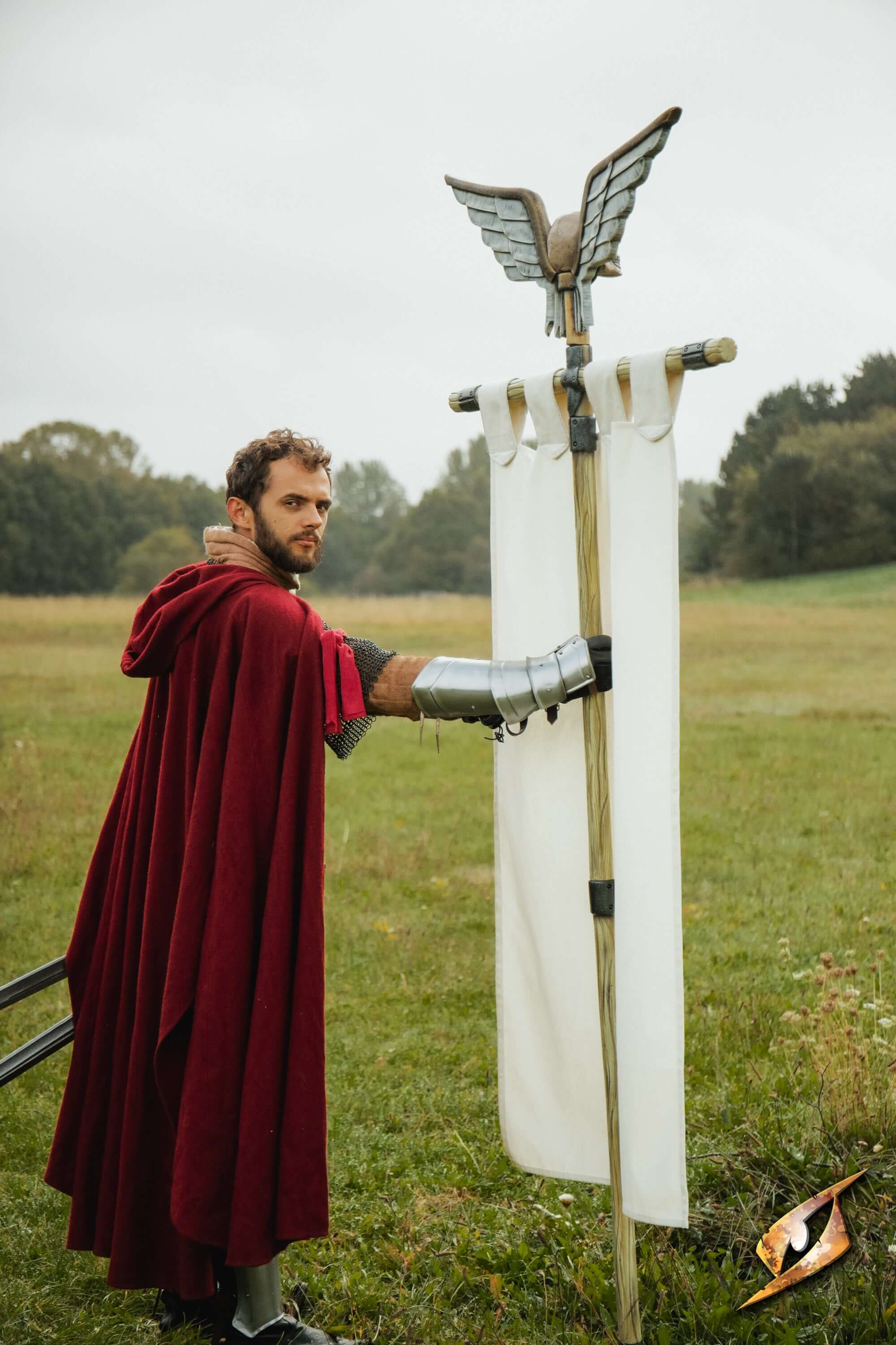 Complete Battle Standard Set - Winged Skull Top displayed by a man in a red cloak with winged skull top outdoors.