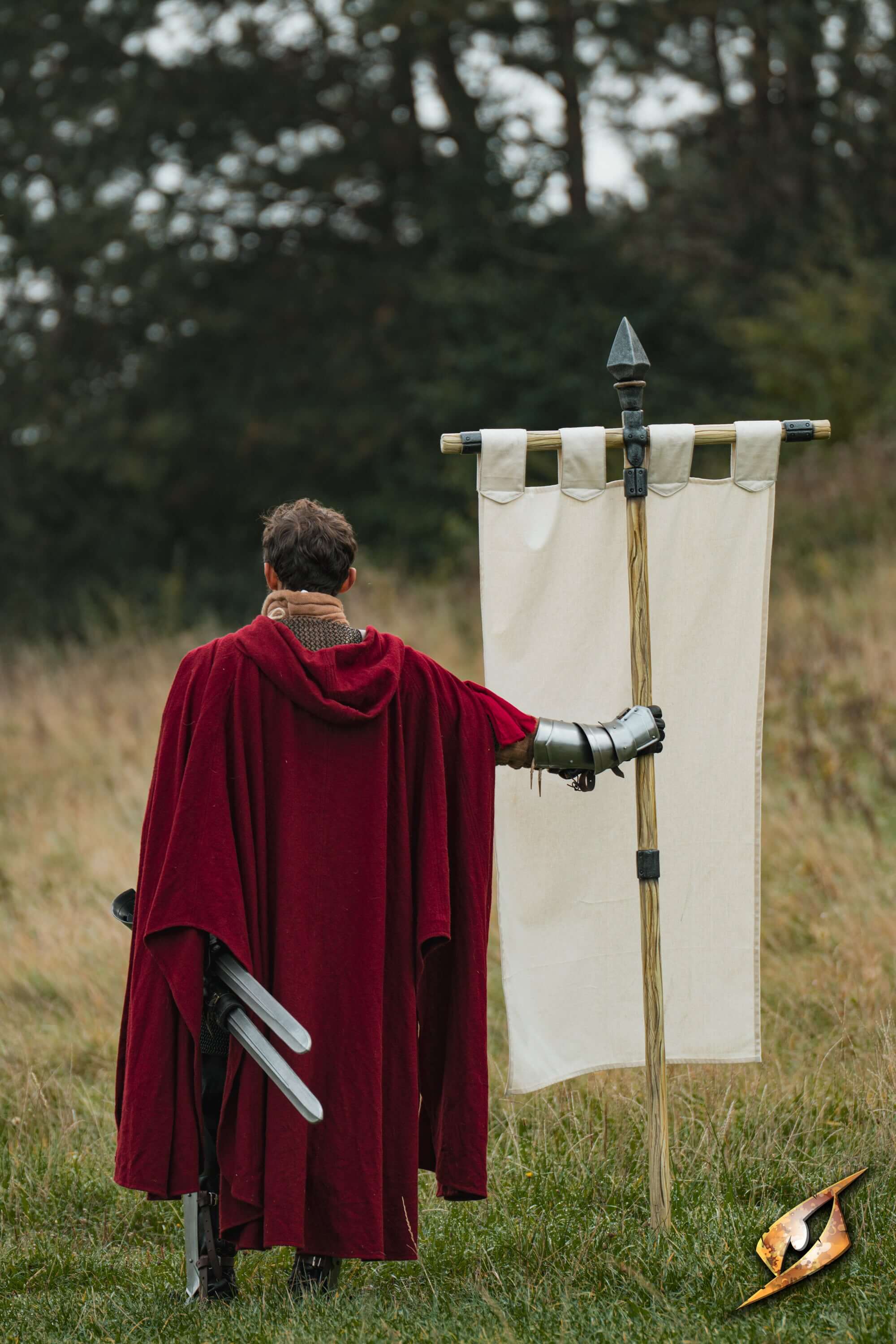 Complete Battle Standard Set - Spear Top displayed with a figure in a red cloak holding a blank banner outdoors.