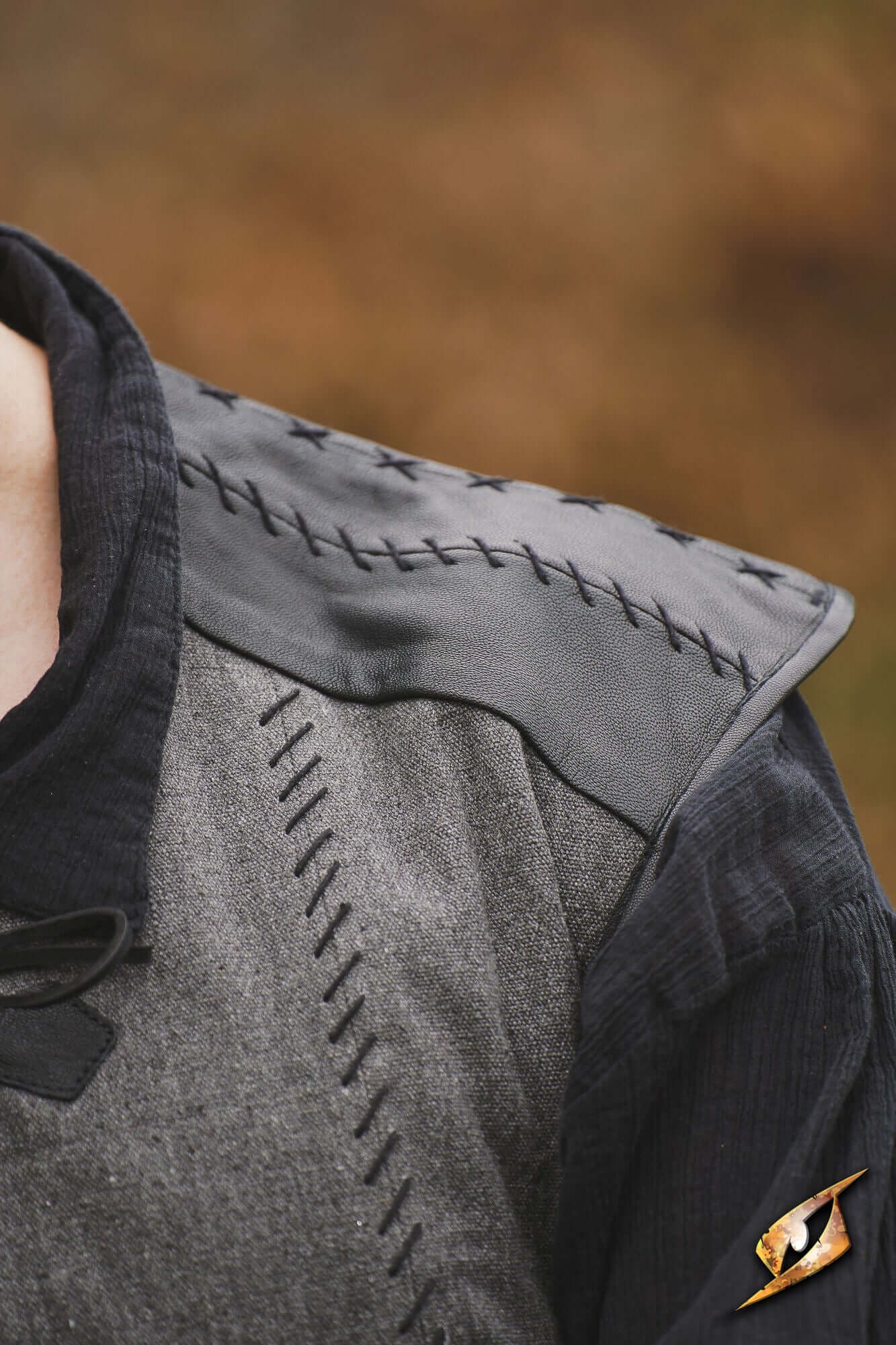 Close-up of the Rugged Canvas Jerkin showcasing chrome leather shoulder reinforcement and decorative hand stitching.