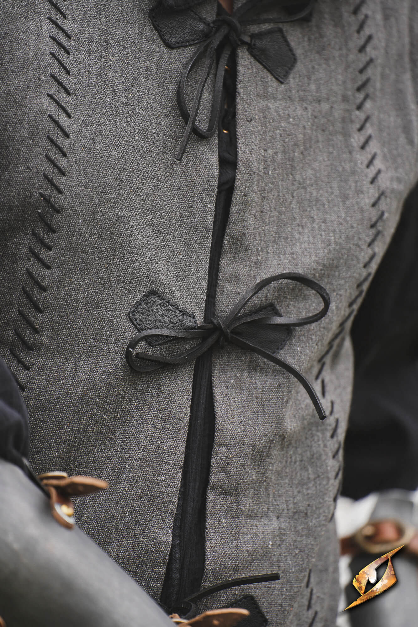 Close-up of the Rugged Canvas Jerkin featuring leather cord ties and decorative stitching.