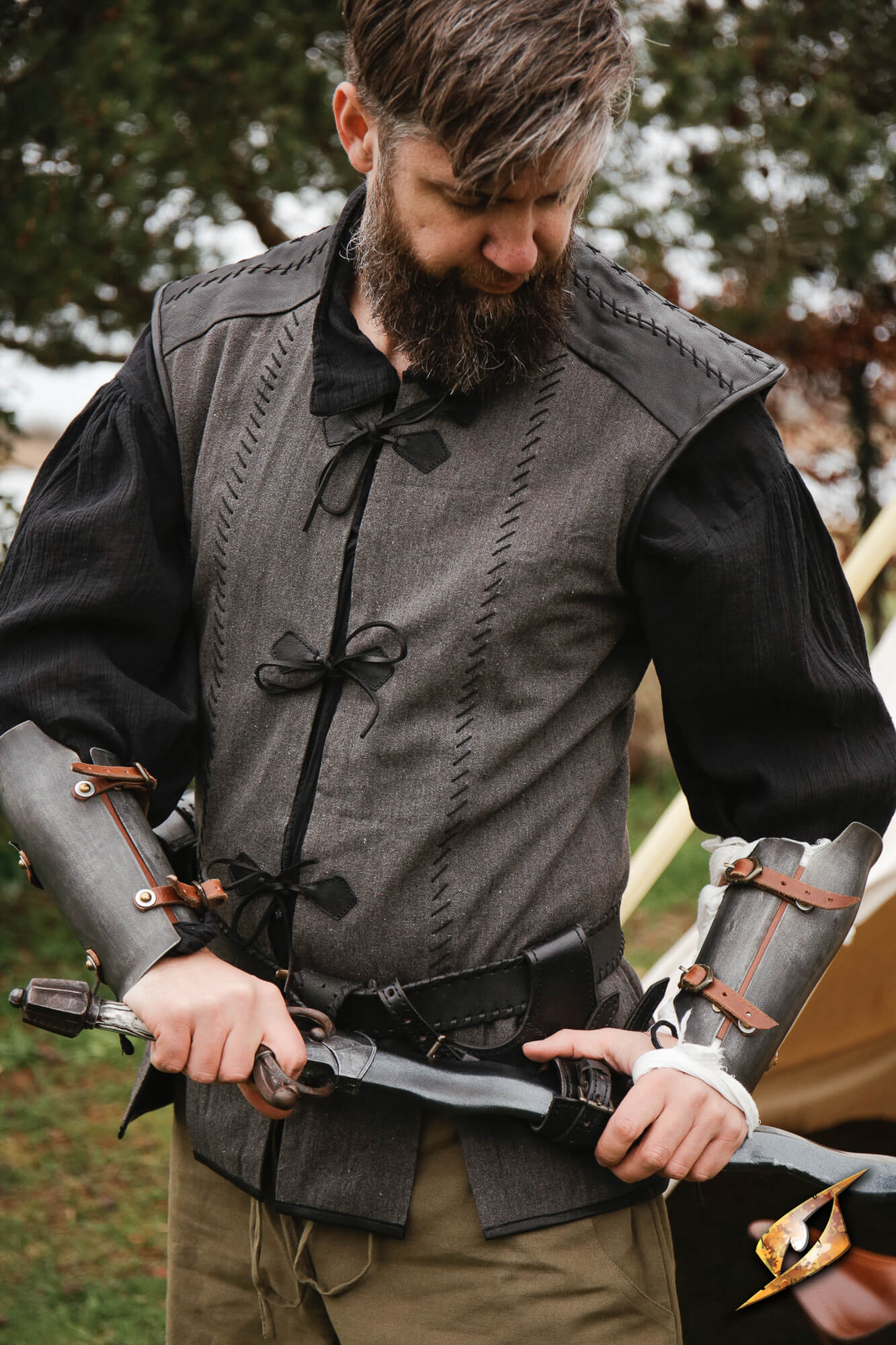Rugged Canvas Jerkin worn by man with sword, showcasing utilitarian design and leather details.