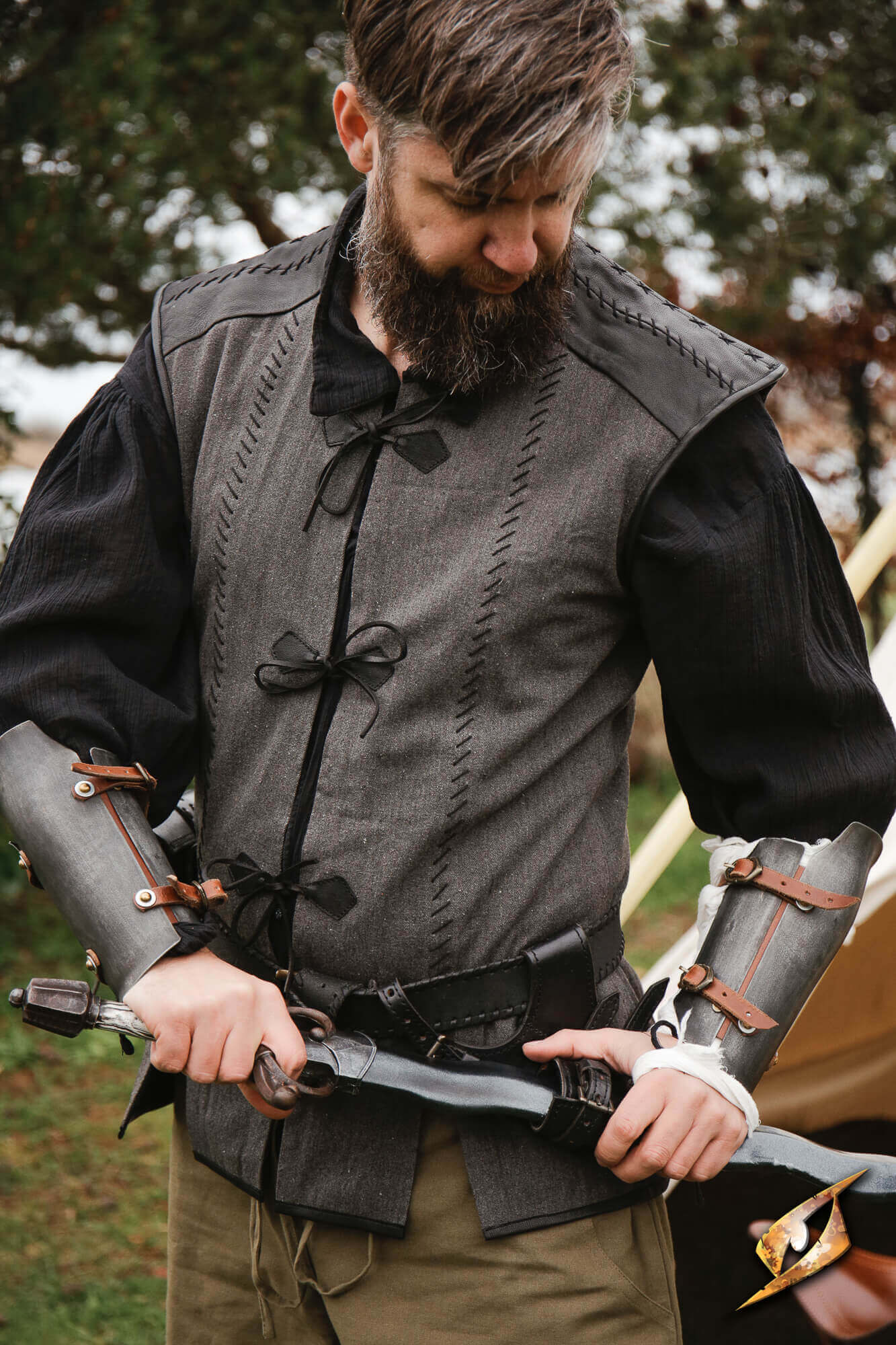 Rugged Canvas Jerkin worn by man with sword, showcasing utilitarian design and leather details.