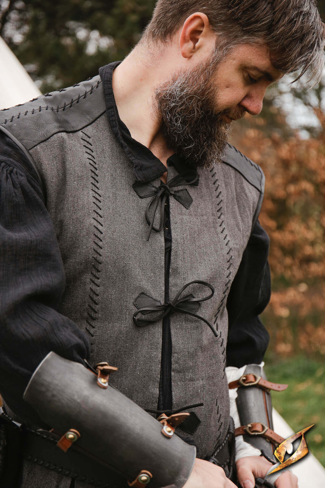 A man wearing a Rugged Canvas Jerkin, showcasing its detailed hand stitching and leather cord ties.