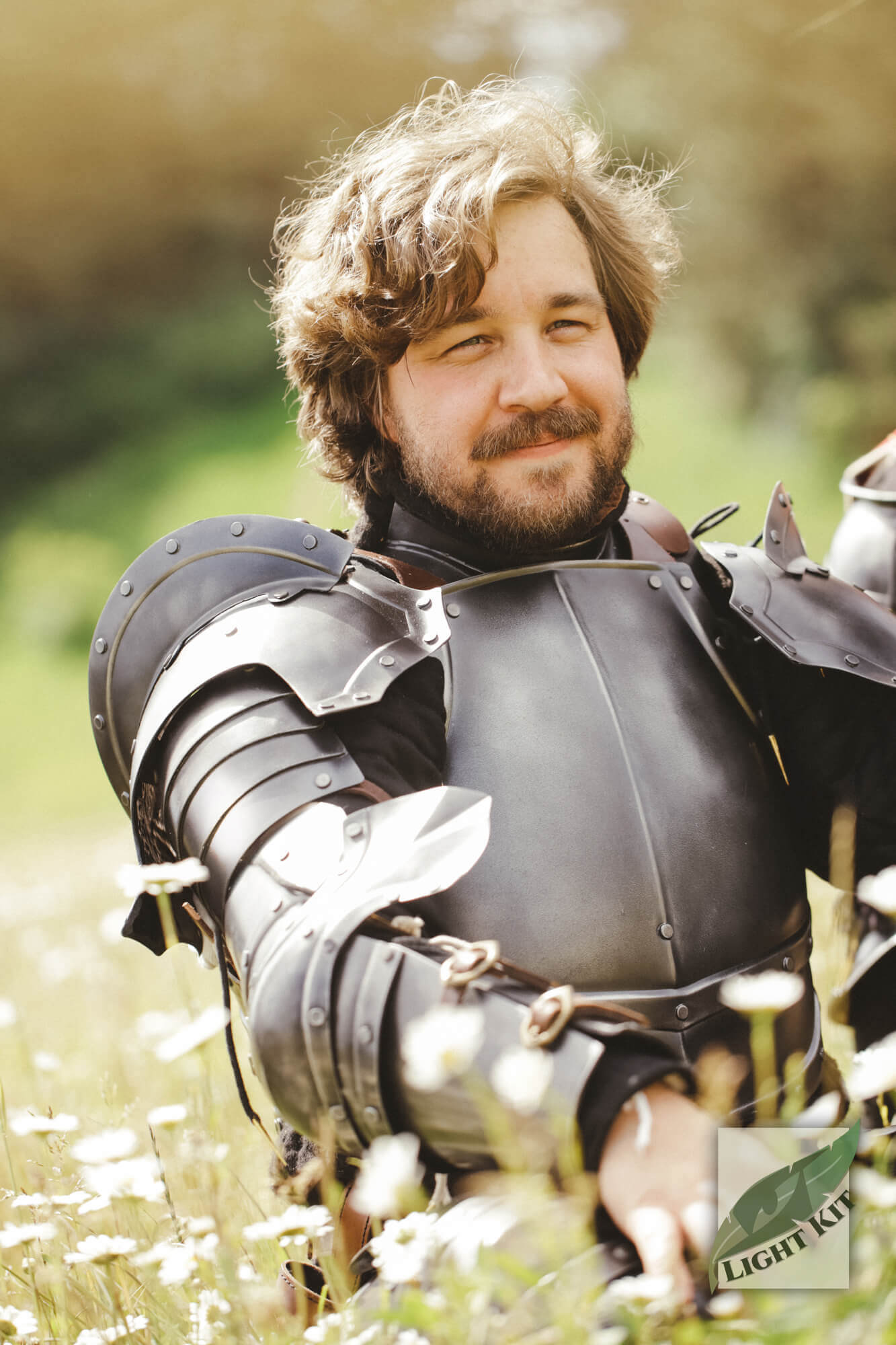 Man wearing the Captain Complete Set - Light Kit armor, showcasing the sleek design in a field of flowers.