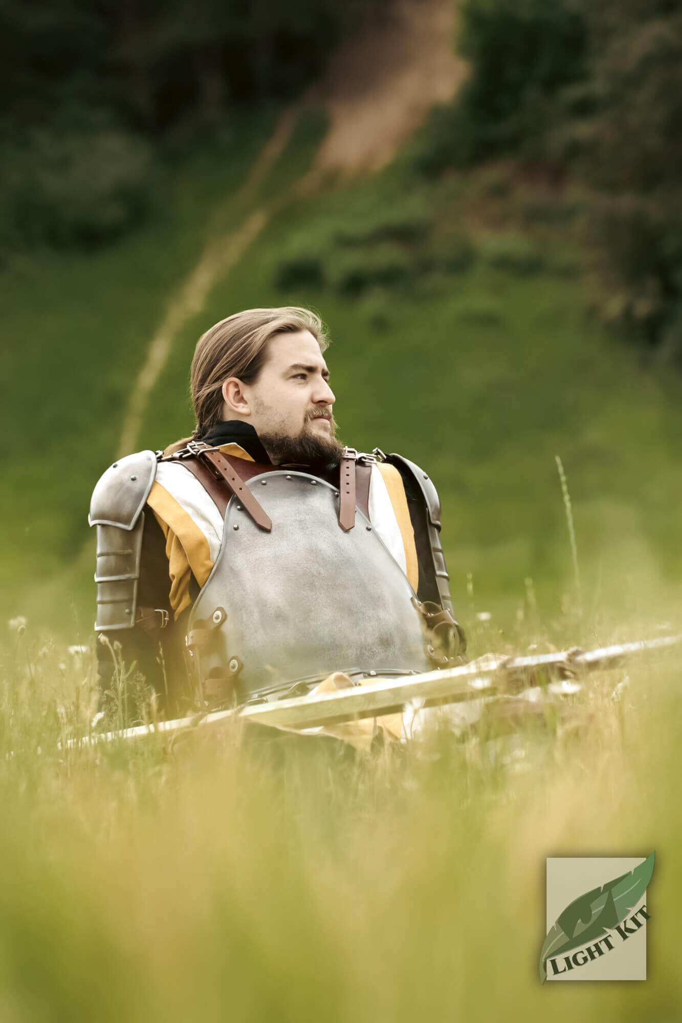 A warrior wearing the Merc Armour Set - Light Kit, showcasing rugged leather and polyurea armor in a grassy field.