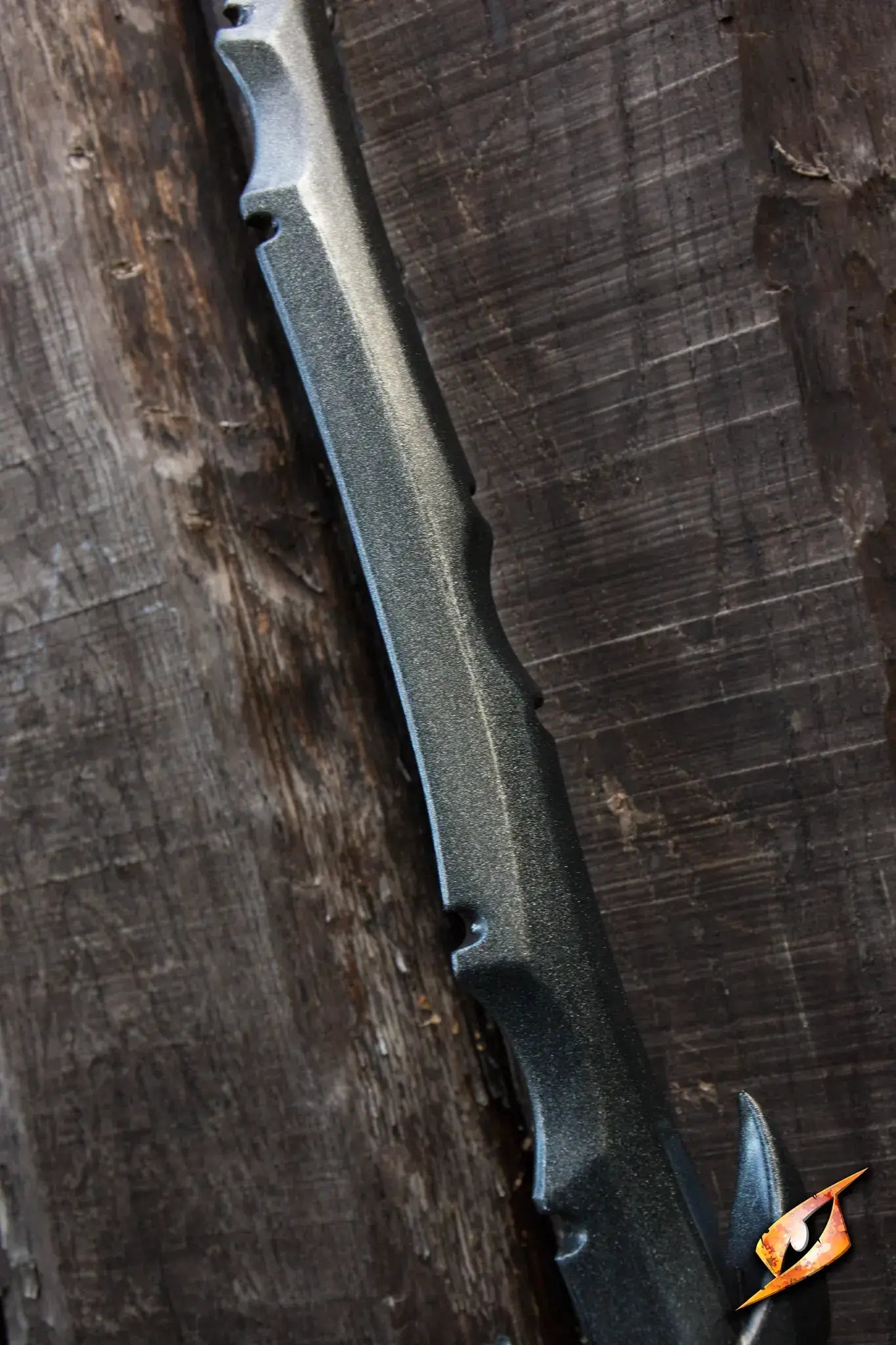 Assassin - 85 cm sword resting against a rustic wooden background, showcasing its sleek blade design.