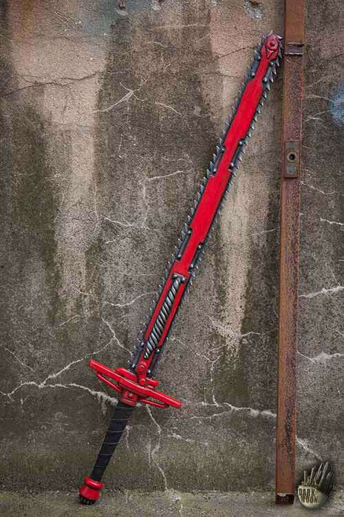 A striking red sword with a serrated edge leaning against a weathered wall.