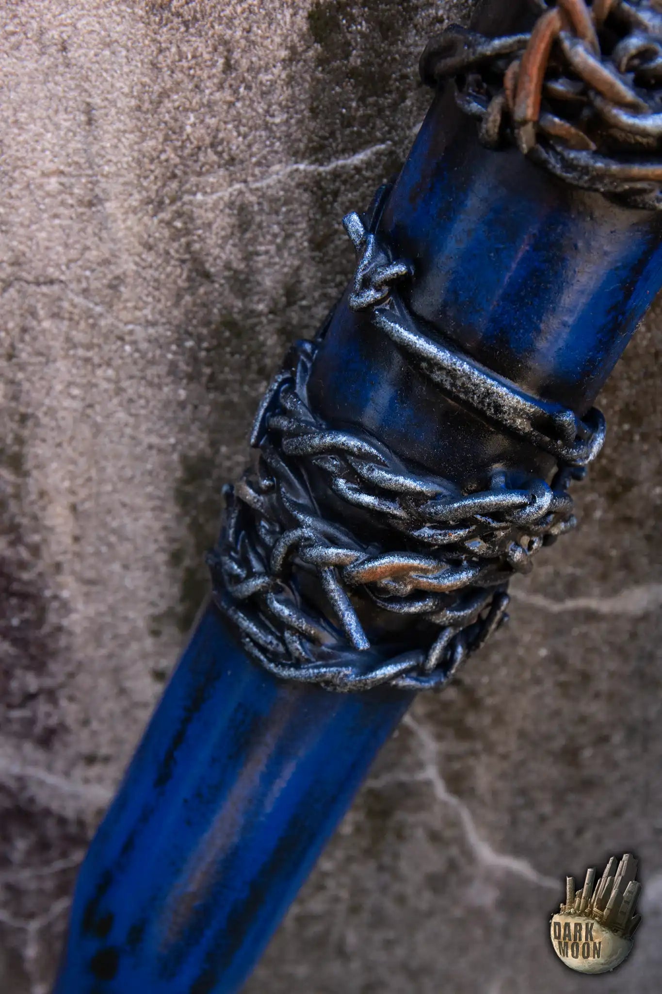 Close-up of the Barbed Wire Bat wrapped in chains and blue paint, designed for post-apocalyptic enthusiasts.