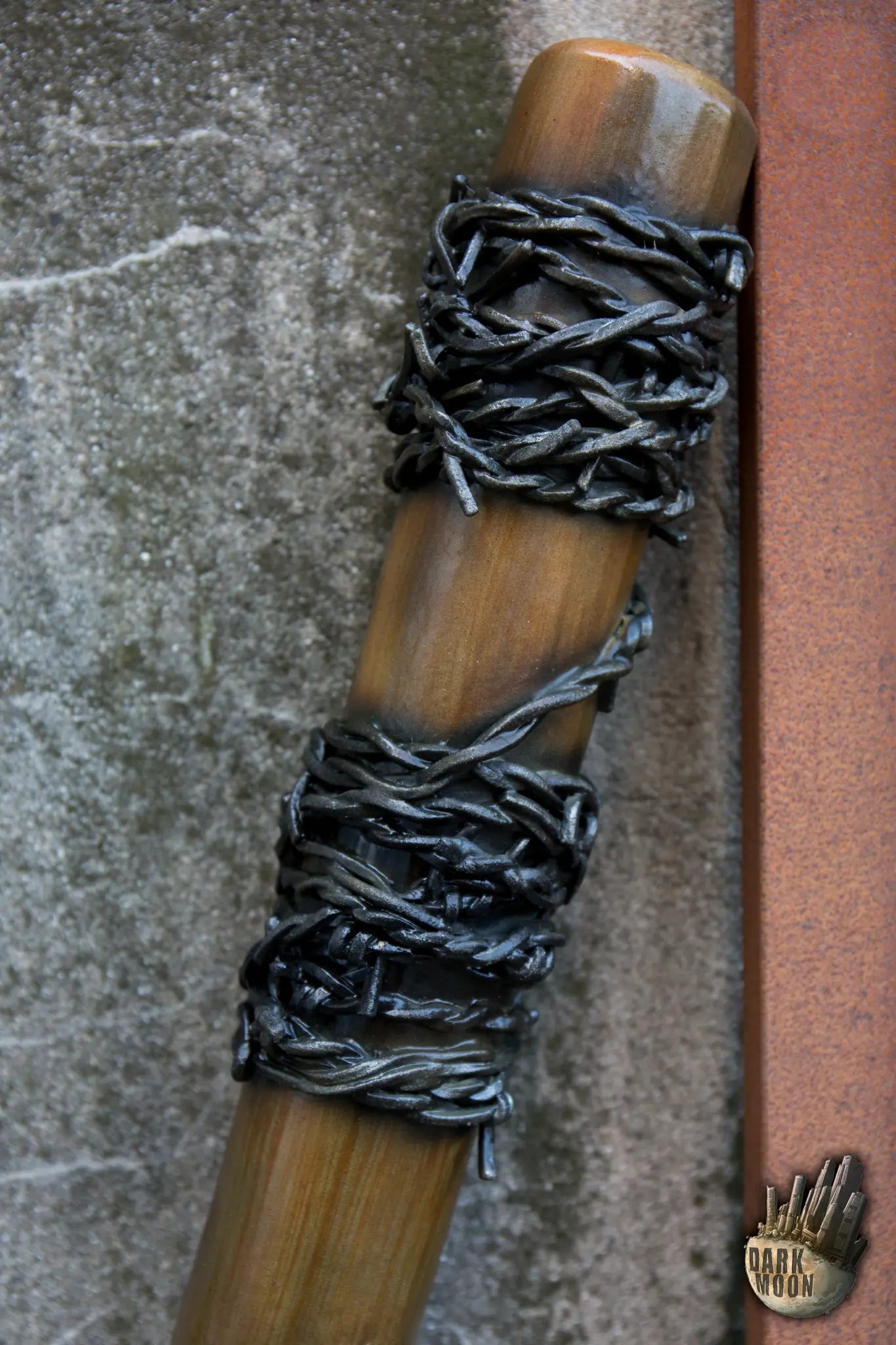 Barbed Wire Bat with black barbed wire wrapping around the wooden handle, perfect for a post-apocalyptic theme.