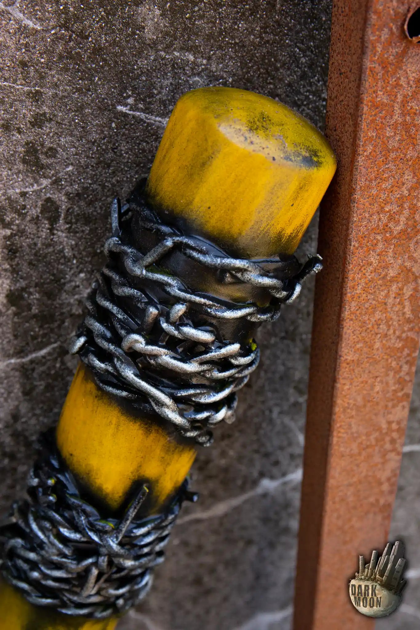 Close-up of a yellow Barbed Wire Bat wrapped with metal chains, perfect for post-apocalyptic scenarios.