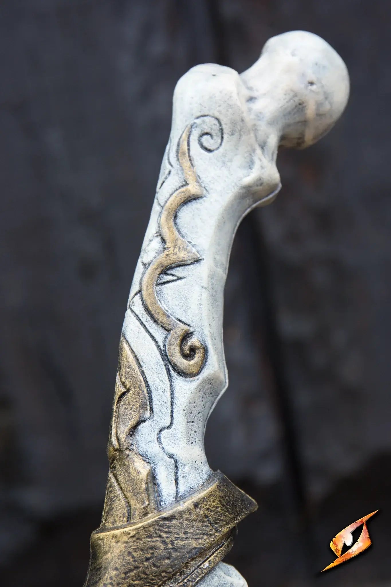 Detailed view of the Bone Scimitar's handle, resembling bleached bone with gold accents.