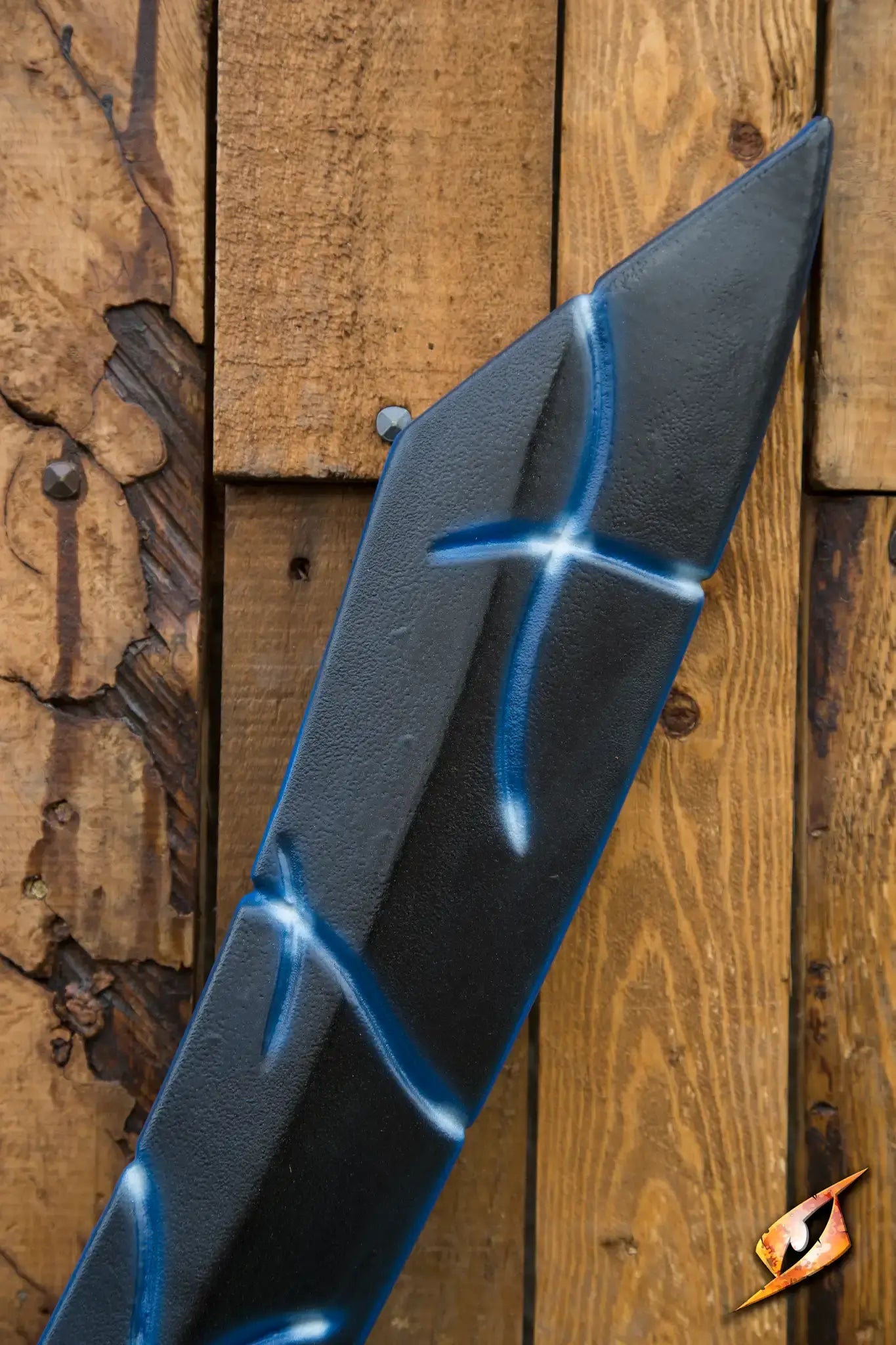 Close-up of a sword with blue accents against a wooden background, representing the Magic Dao.