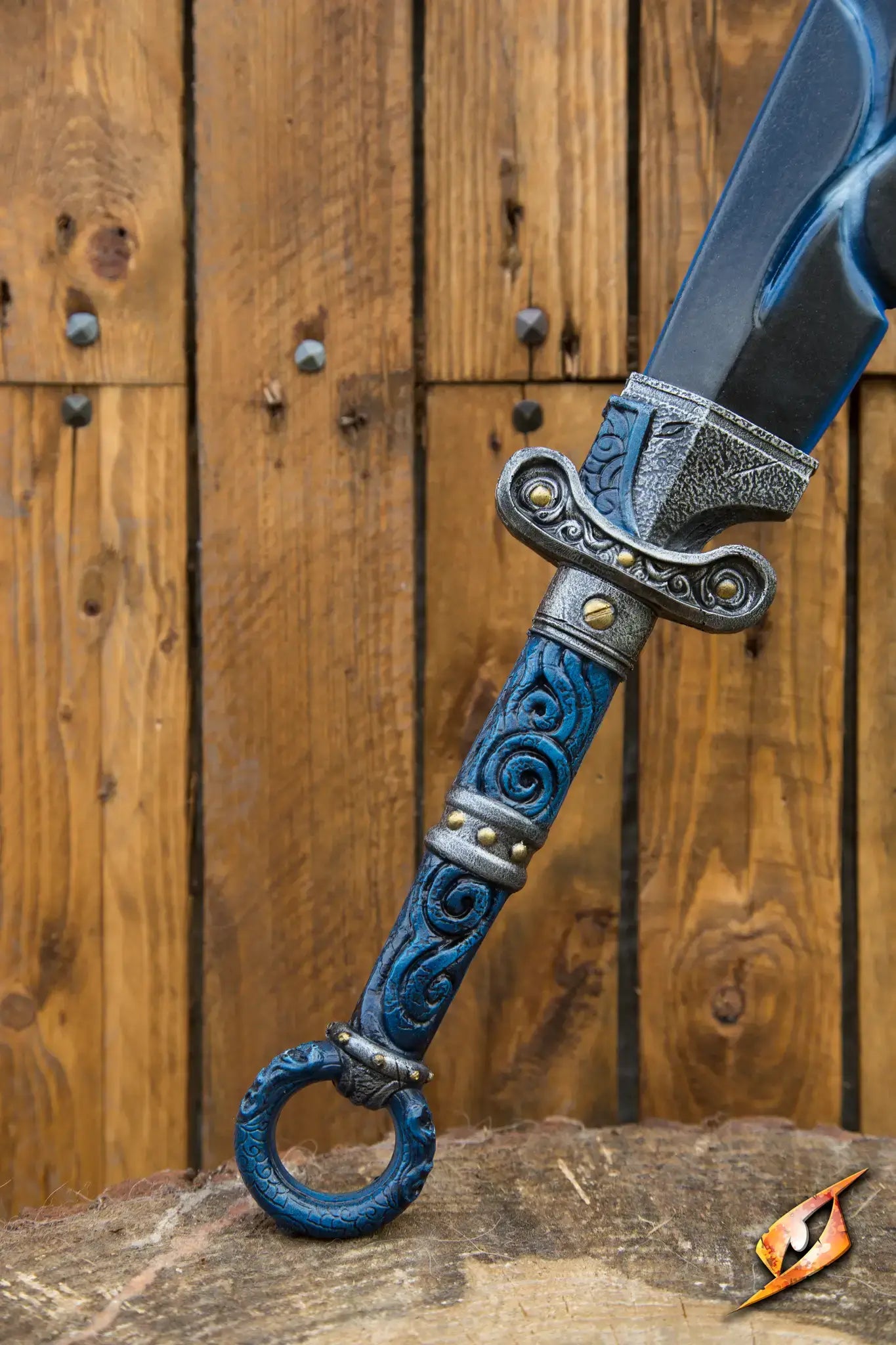 Close-up of a beautifully designed sword with blue accents and intricate details, displayed against a wooden backdrop.