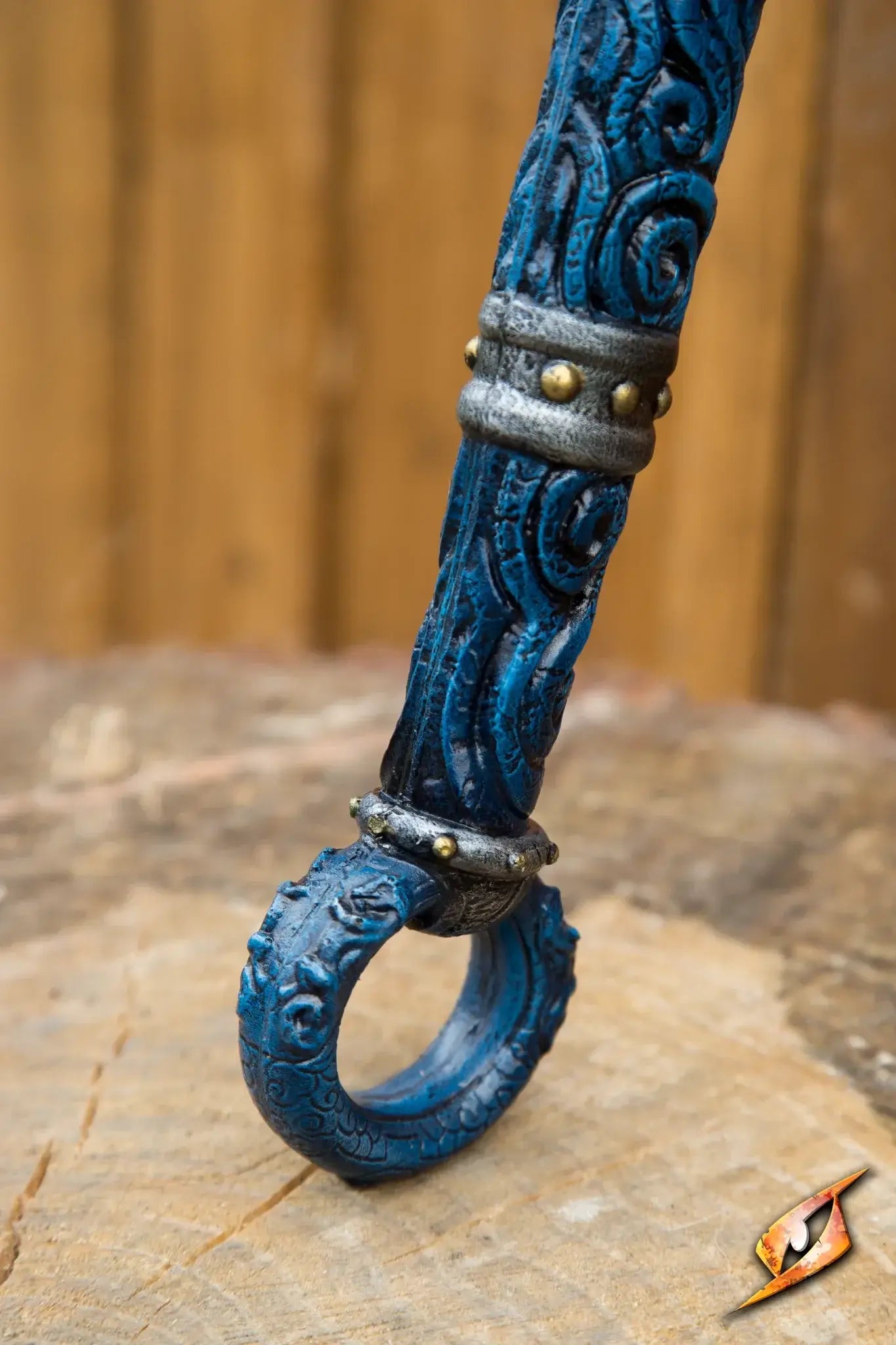 Magic Dao intricately designed staff with blue carvings, resting on a rustic wooden surface.