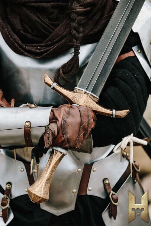 Close-up of a armored warrior gripping a wooden sword, showcasing intricate details of the armor and weapon.