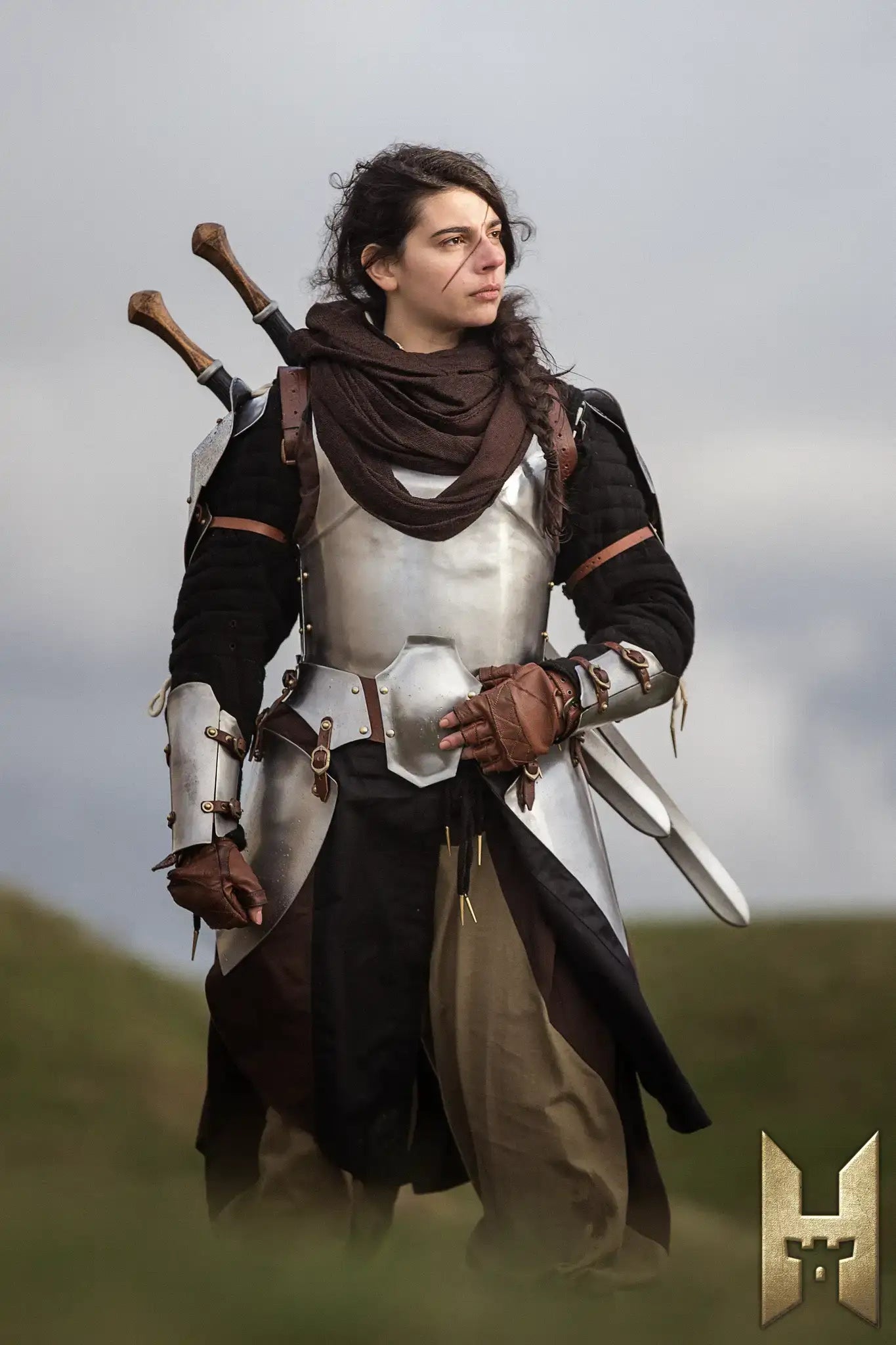 Person in armor holding a Bastard Sword, showcasing a medieval fantasy look and strong character presence.